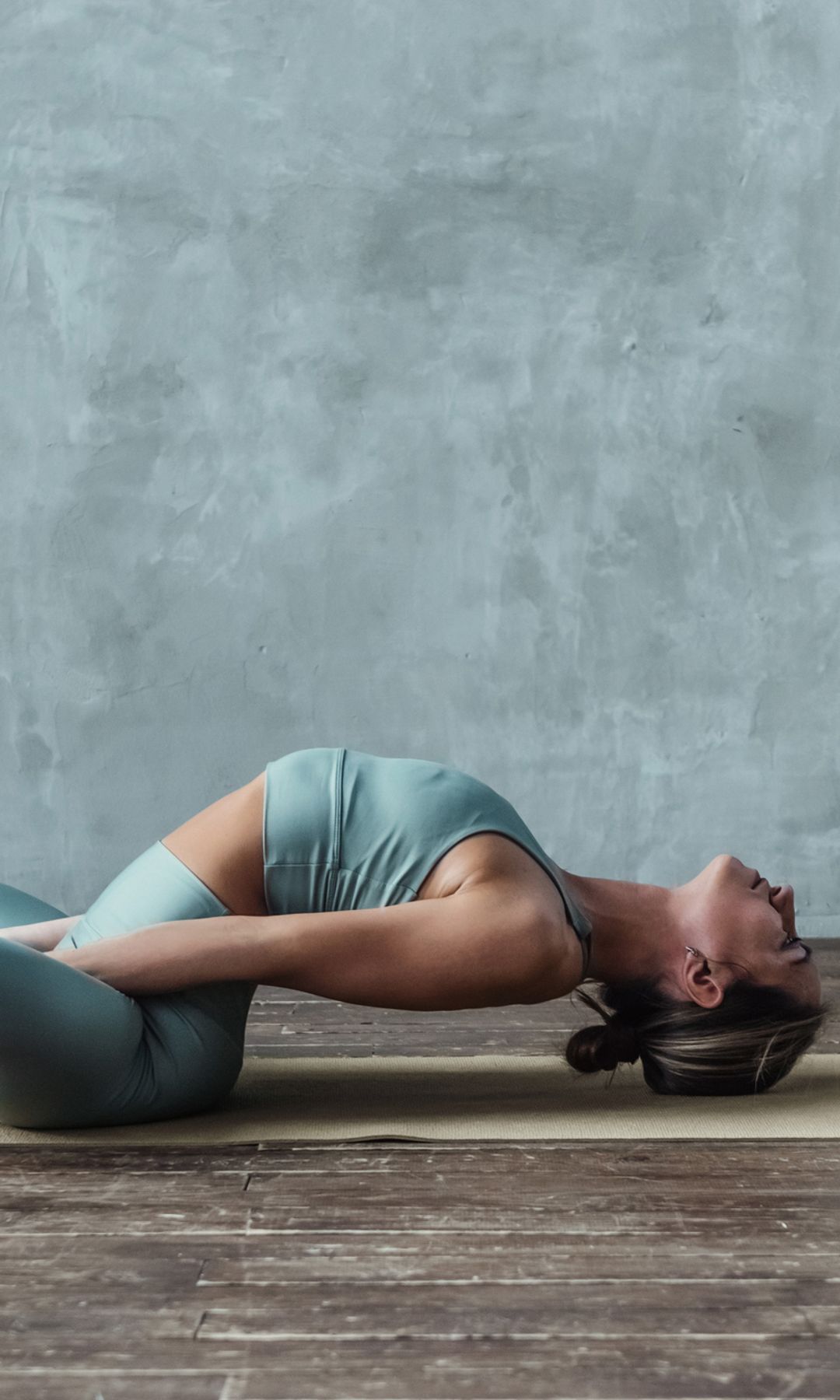 Una mujer con una postura de yoga restaurativa