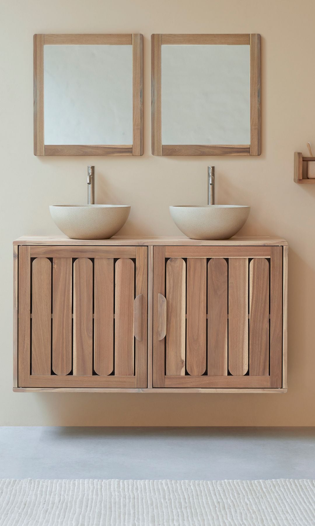 Baño con mueble suspendido de madera, lavabos sobre encimera redondo, dos espejos con el marco de madera, estante para los accesorios y perchero de pie de madera