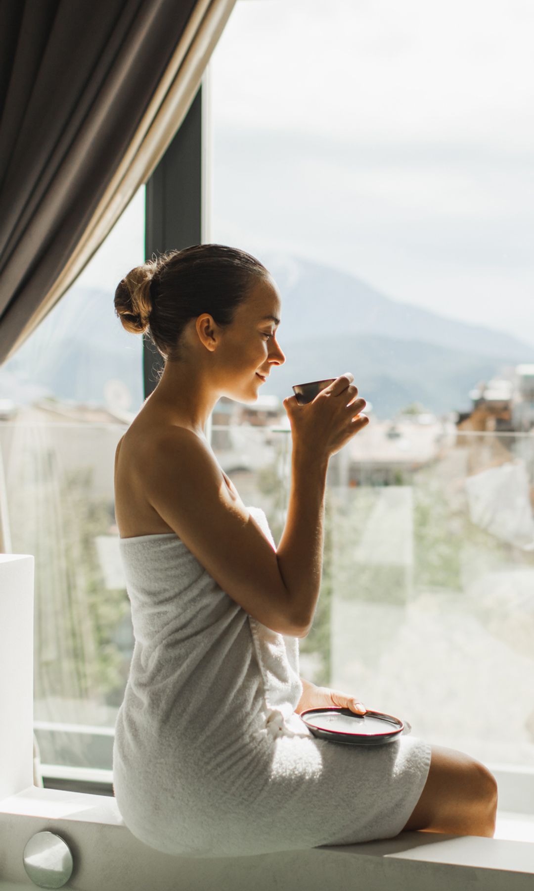 Mujer en albornoz tomando té