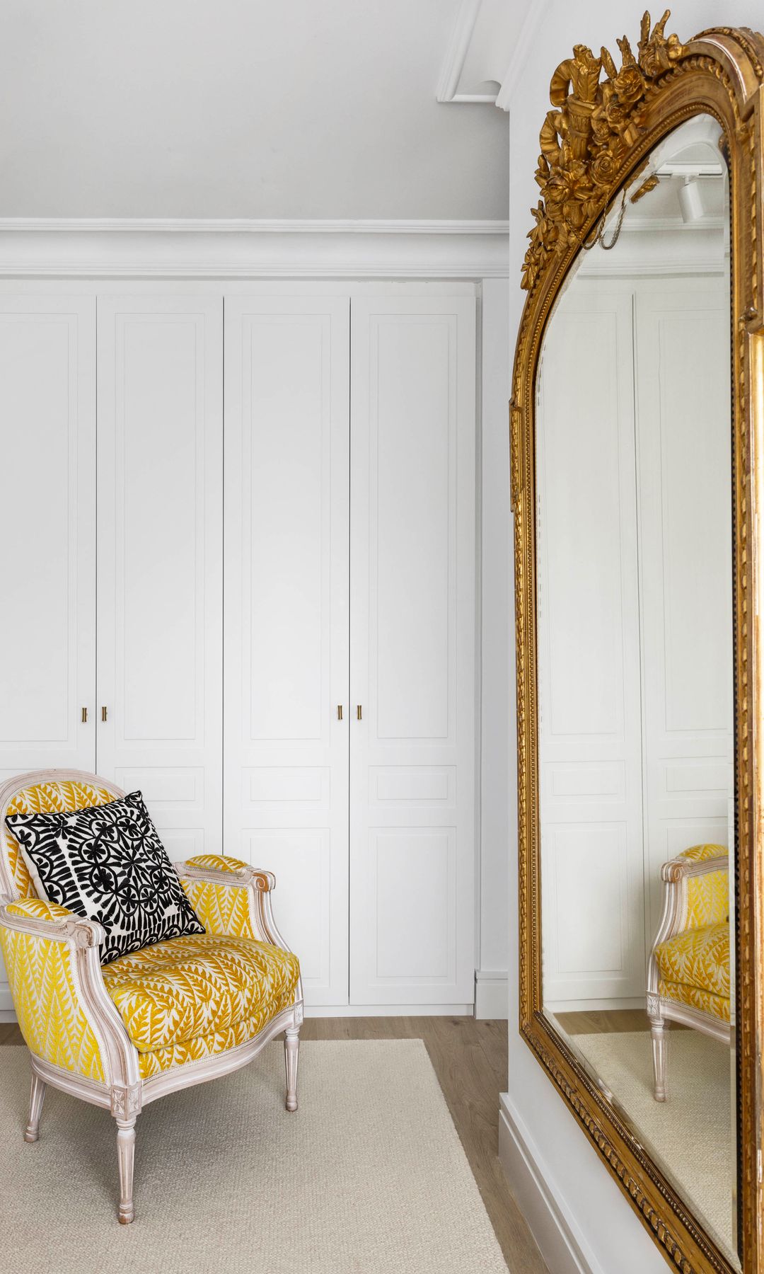 Vestidor con espejo dorado XL, butaca amarilla, alfombra, armarios lacados en blanco