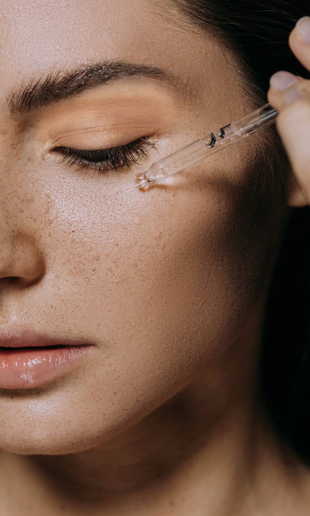 Aplicación de sérum facial con gotero en el contorno de ojos