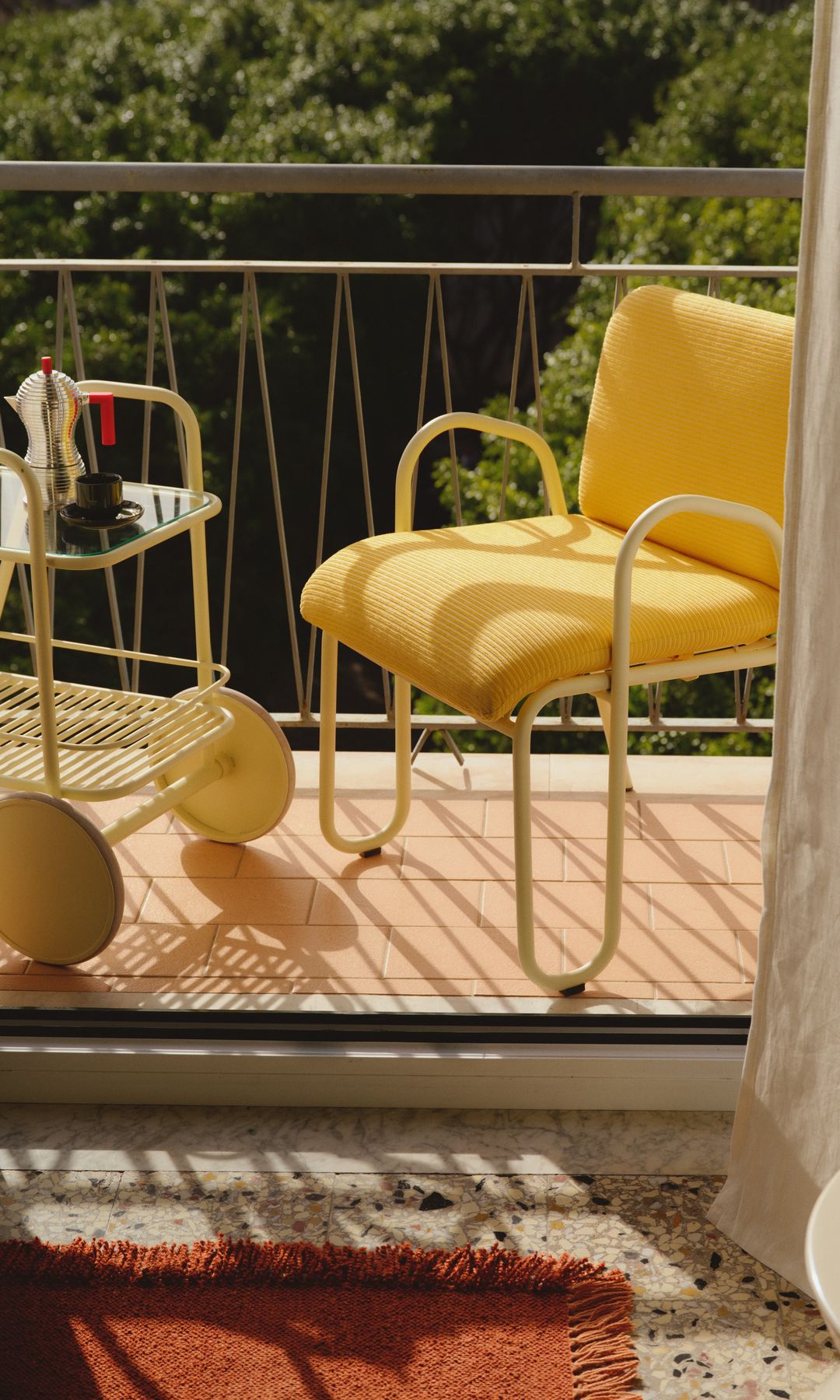 Balcón con carrito con ruedas amarillo, silla amarilla 