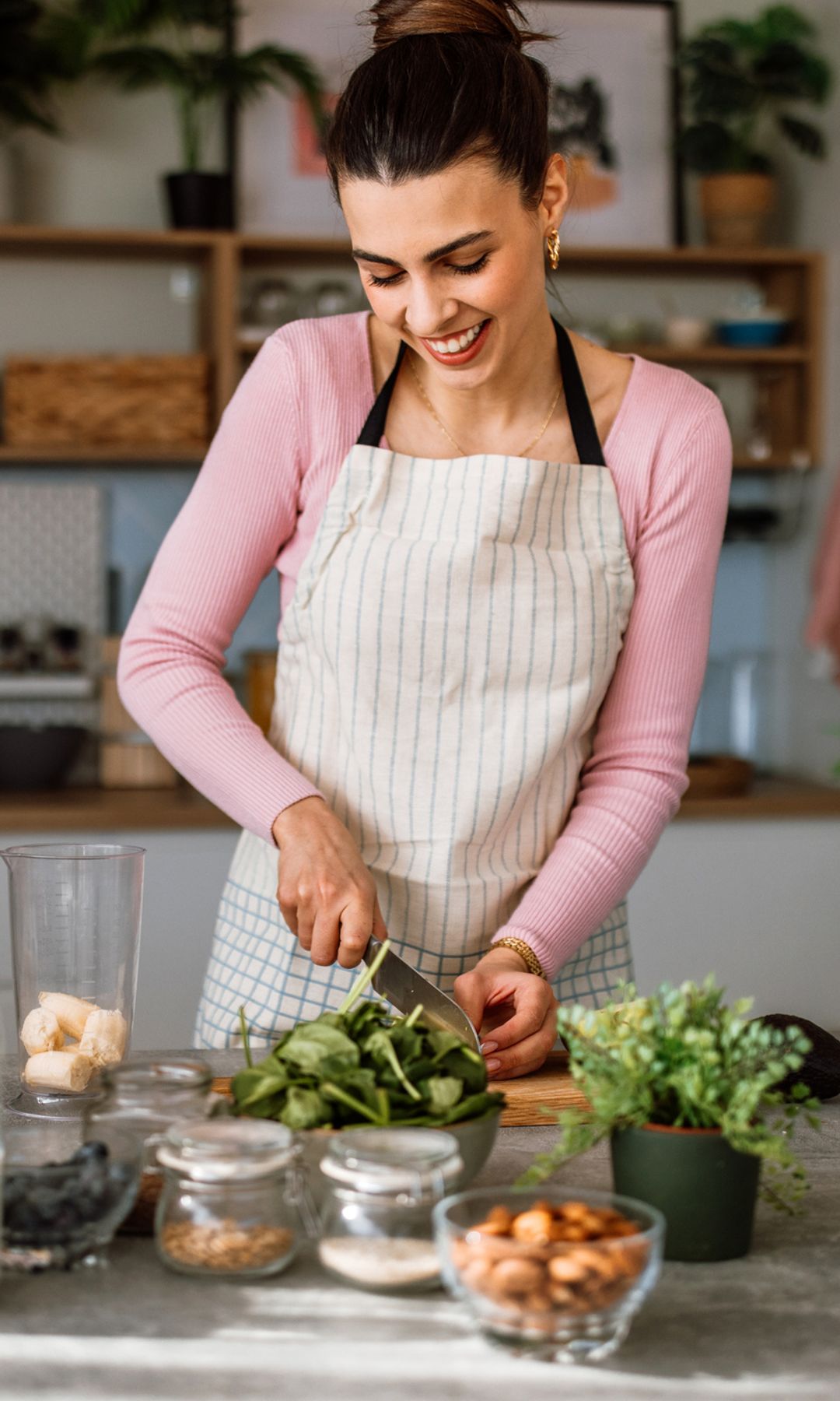 Mujer feliz cocinando para asegurar proteger su segundo cerebro y ser más feliz según Mario Alonso Puig