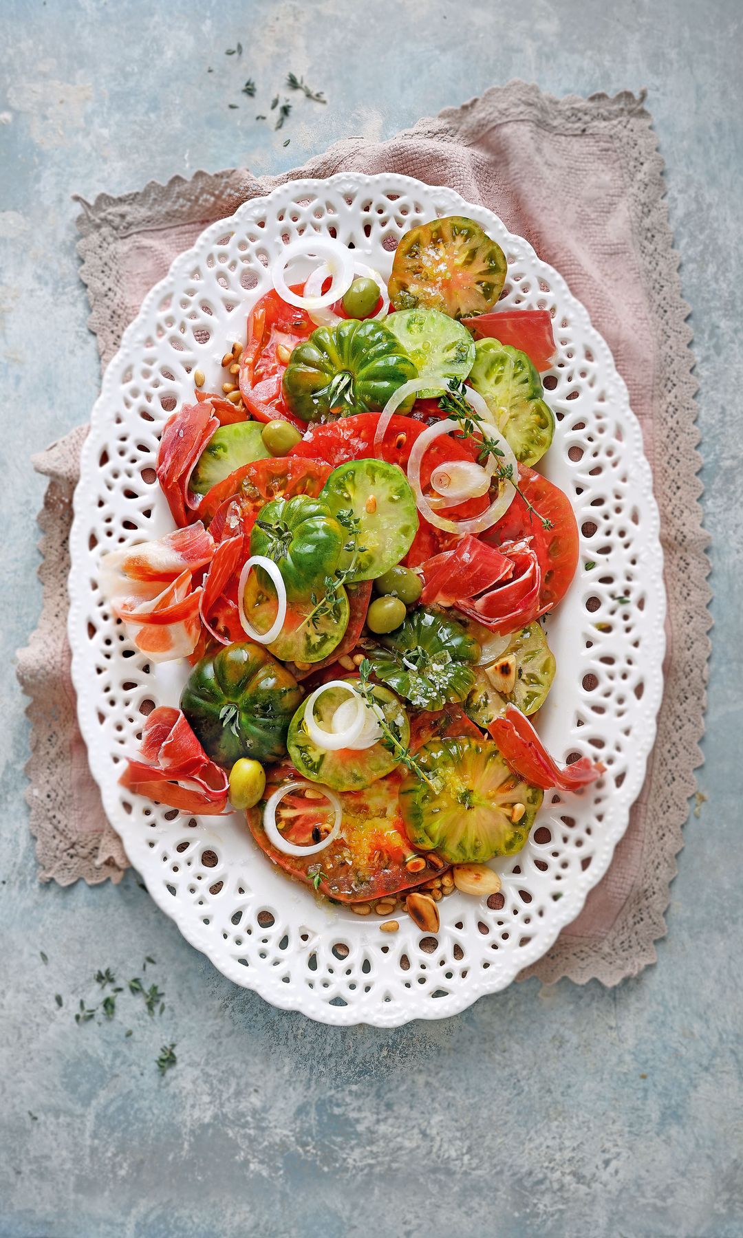 Rodajas de tomate verde y rosa con ibérico y almendras tostadas
