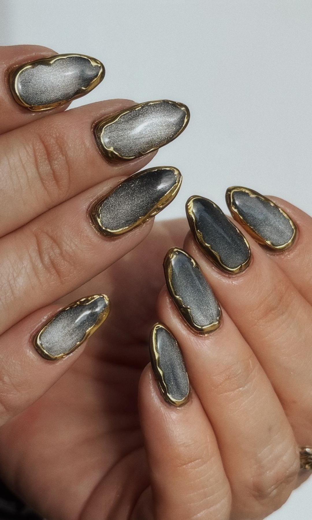 Manicura gris con detalle dorado
