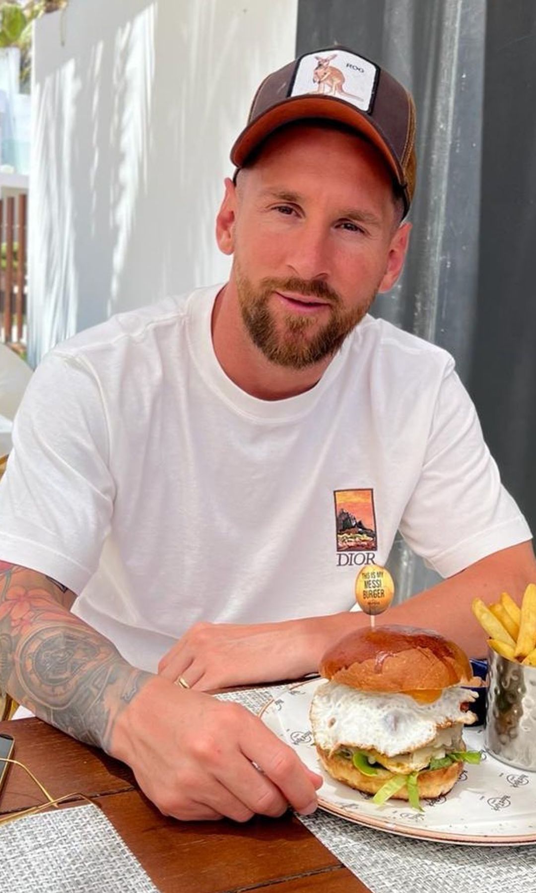 Leo Messi sentado a pie de campo con equipación rosa y sus nuevos botines de Adidas