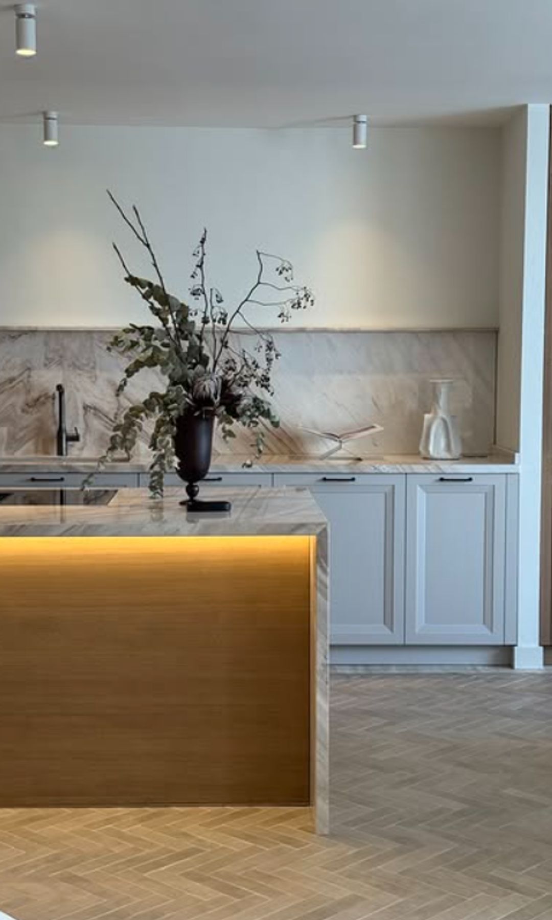 Cocina con isla con luces en el techo, bajo la isla y en los armarios, suelo de madera