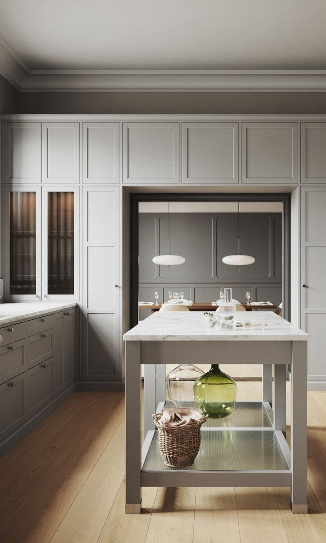 Cocina con armarios hasta el techo, mesa de cocina en el centro y muebles en color gris, suelo de madera 