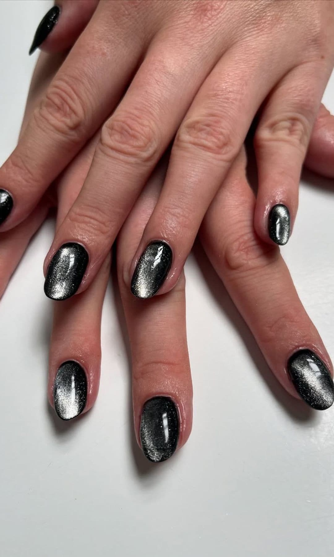 Manicura efecto velvet en negro con acabado magnético y brillo metálico sobre uñas almendradas