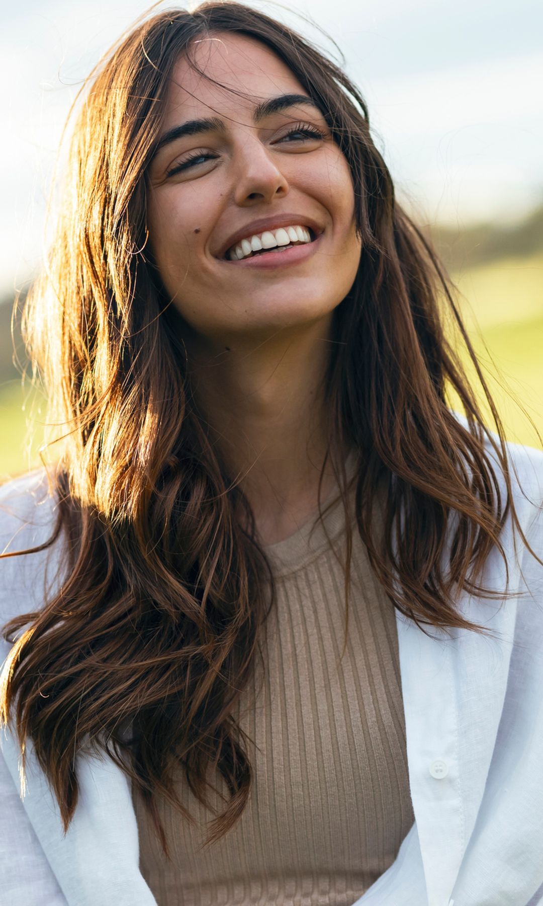 Mujer feliz y serena sonriendo en el campo 