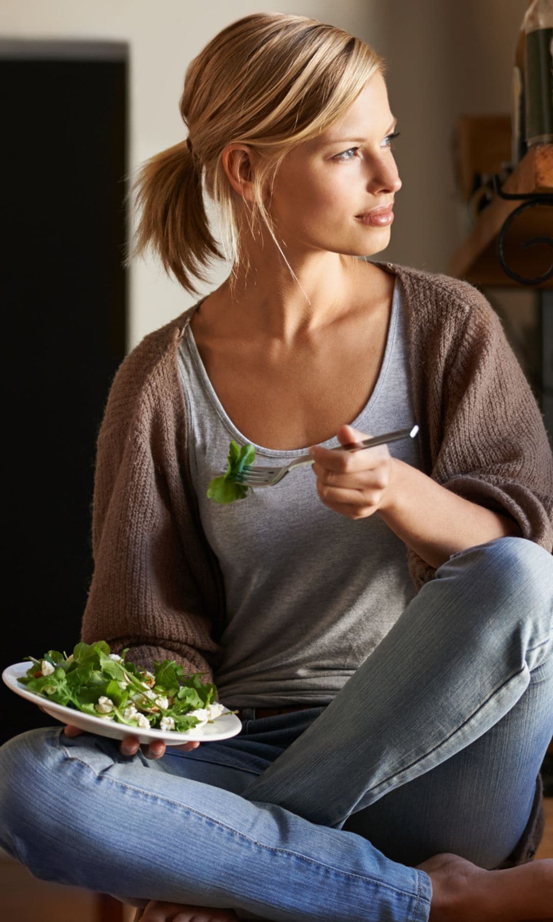 Mujer rubia comiendo ensalada