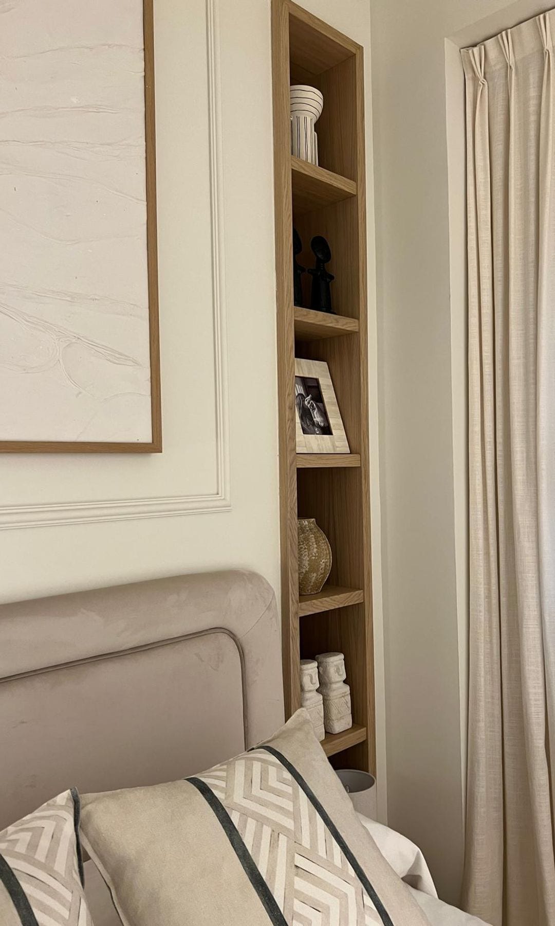 Dormitorio con cabecero tapizado, librería en hornacina molduras, cojines, cortinas