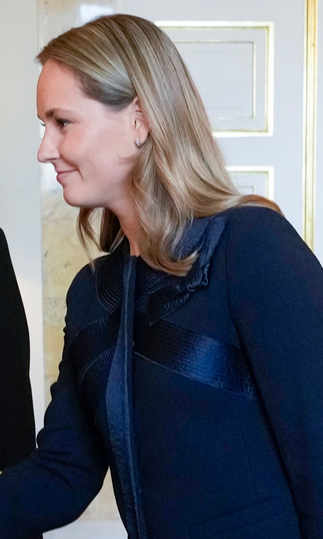 La princesa Ingrid de Noruega con traje de chaqueta azul marino recibe a los representantes de la Operación Dagsverk en la audiencia en el castillo