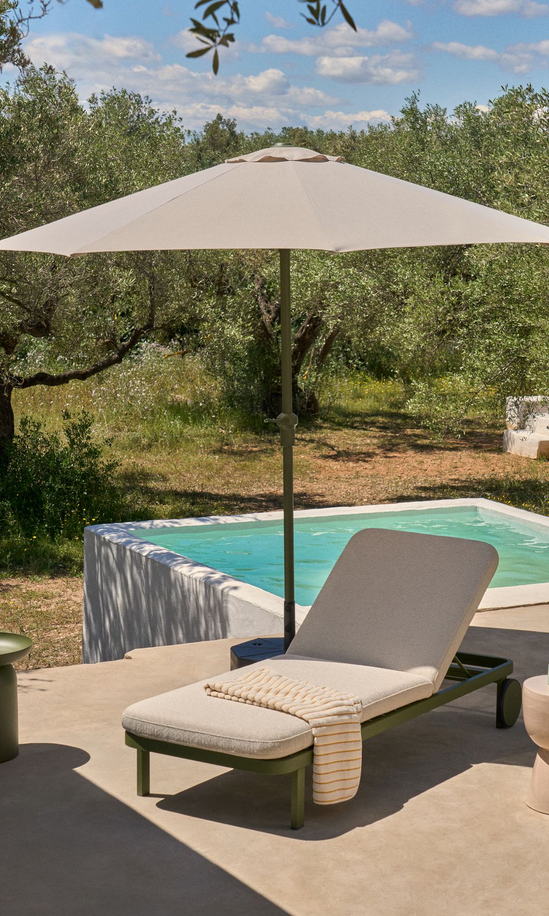 Tumbona de Kave Home junto a una piscina tipo alberca