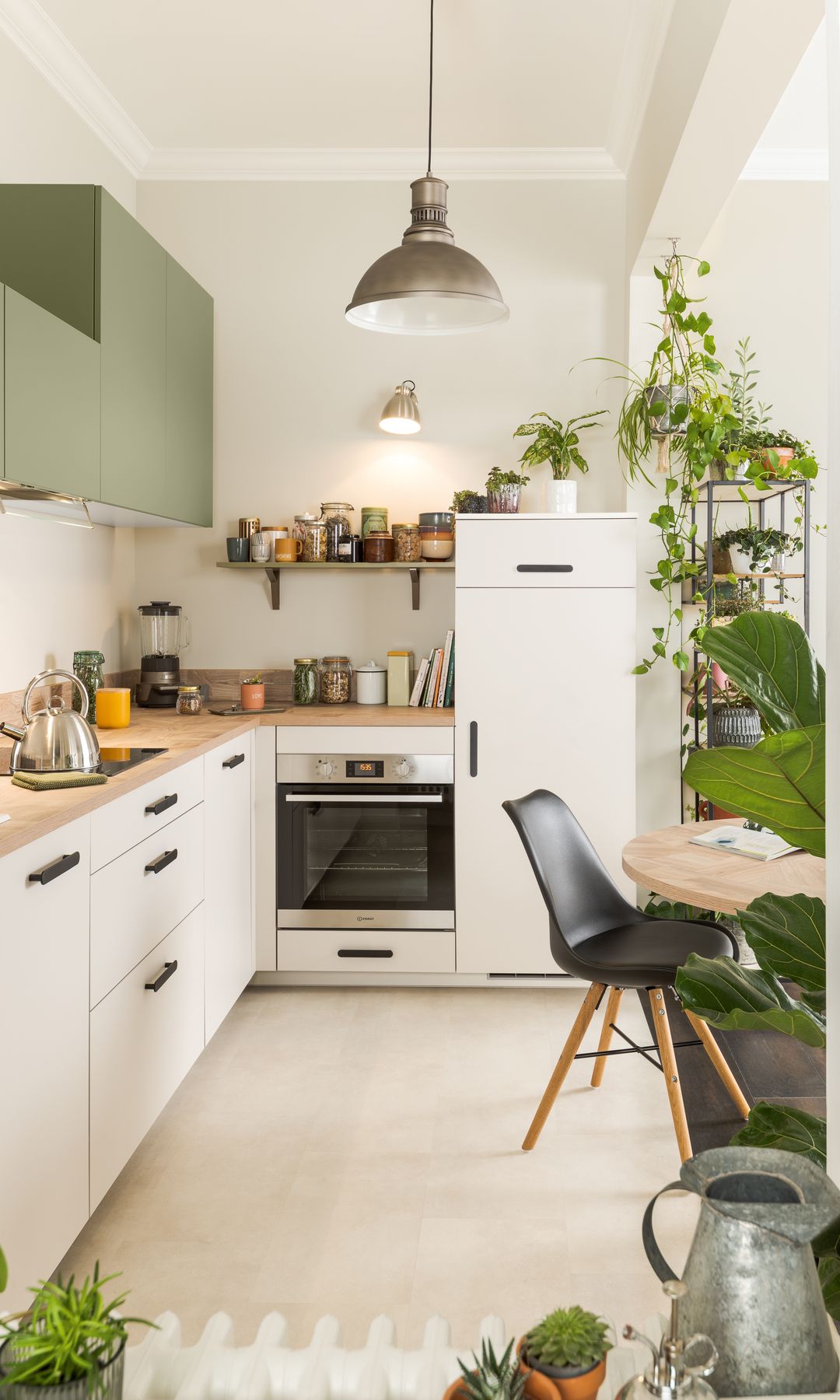 Plantas con muebles en blanco y verde, plantas sobre la nevera, la encimera y la mesa, lámparas de techo