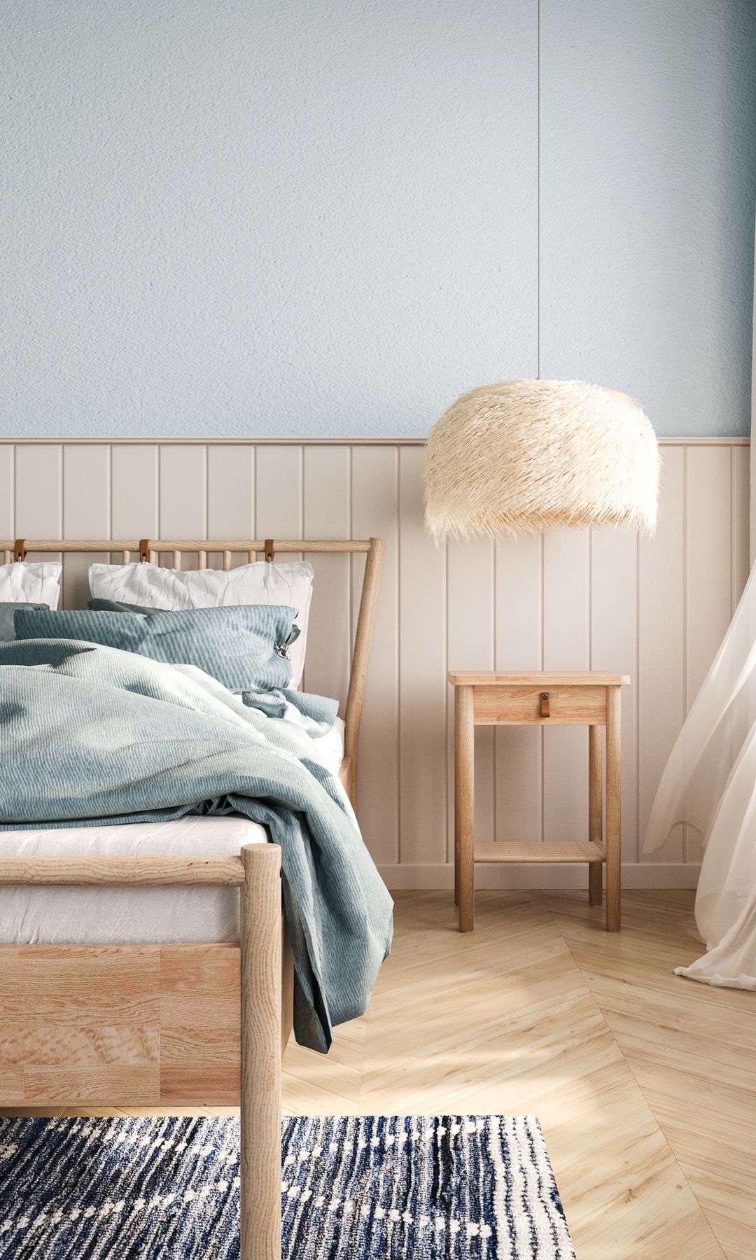 Dormitorio en tonos azules y blancos, con mobiliario de madera: una cama, una lámpara colgante de techo y una mesilla, además de una pequeña alfombra bajo la cama.
