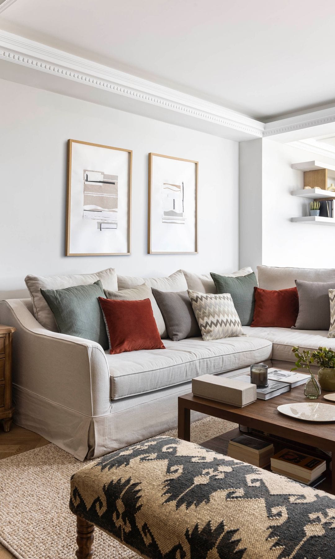 Salón con sofá con cojines y cuadro collage