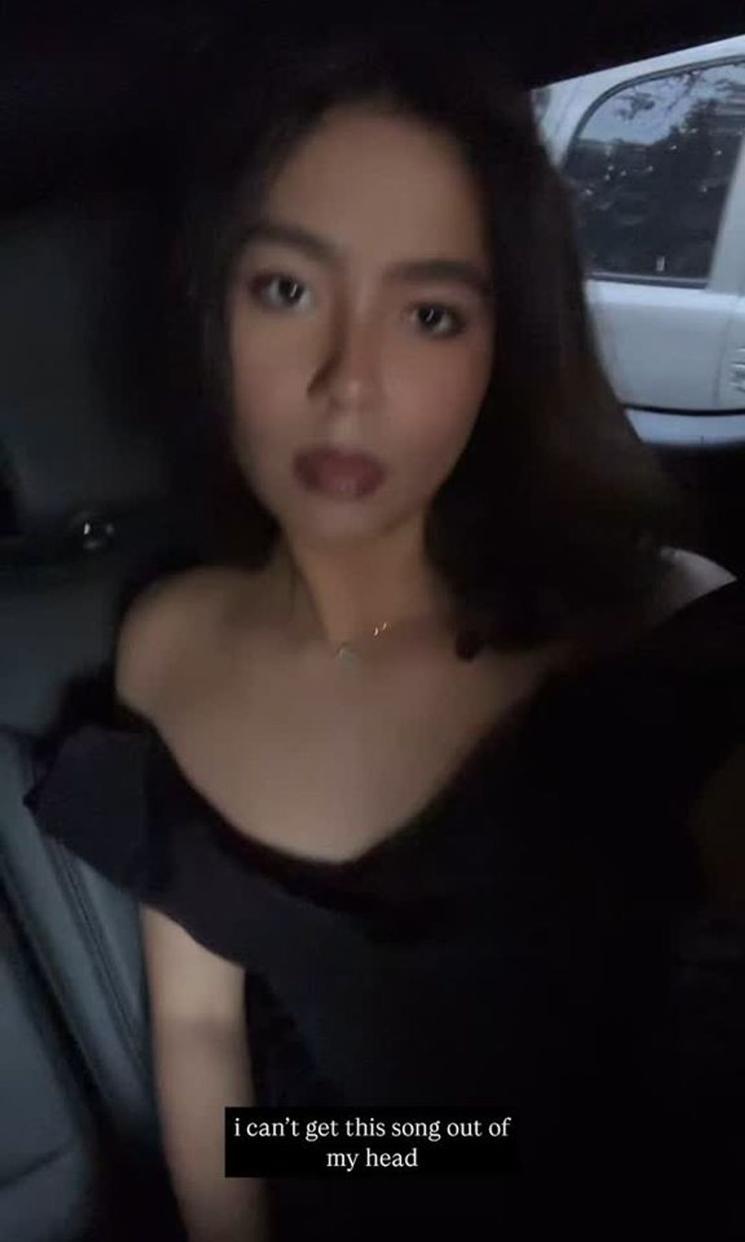 Monroe, hija de Mariah Carey, con un vestido negro de hombros descubiertos, sentada en un auto, con maquillaje suave y el cabello lacio.