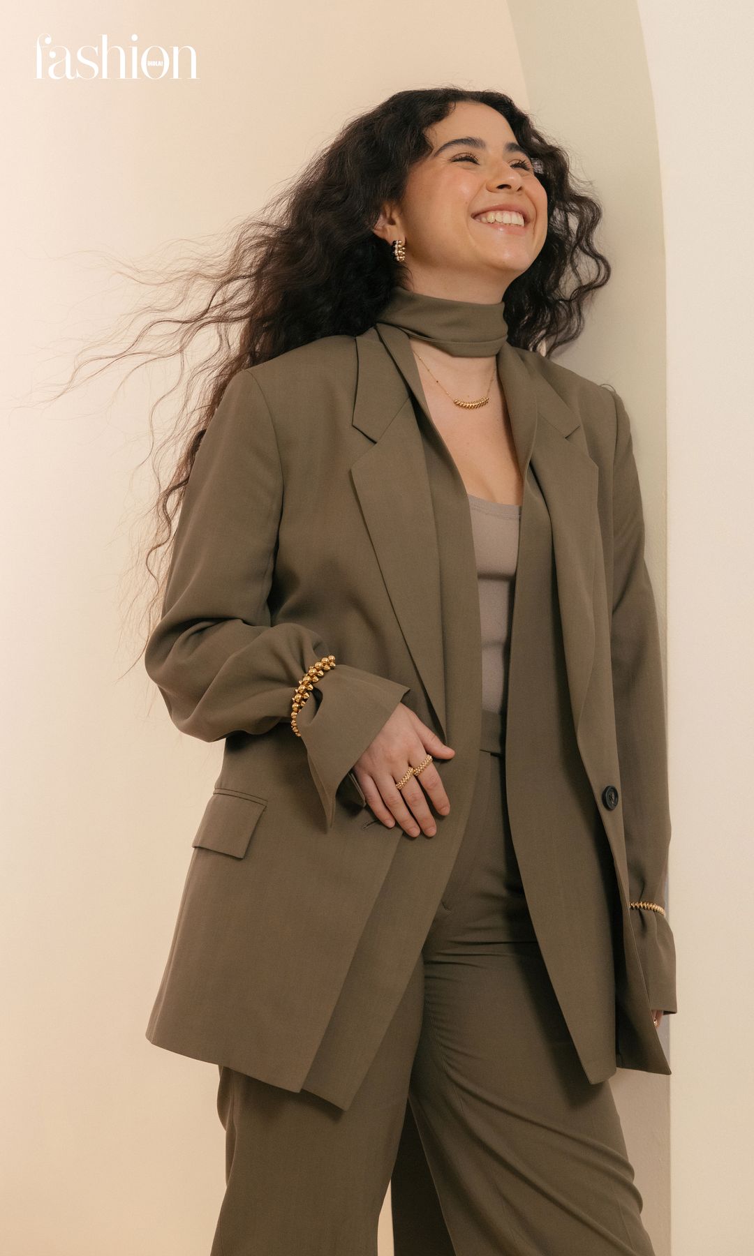 Silvana un elegante conjunto verde olivo, que incluye un saco y pantalón estilo sastre de Ferragamo, destacando su estilo único y moderno. El conjunto se completa con joyería de la exclusiva colección «Clash» de Cartier, en oro amarillo, diamantes y ónix.