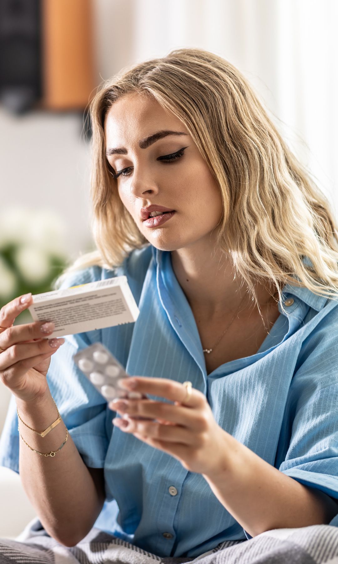 Mujer joven revisando el prospecto de un medicamento