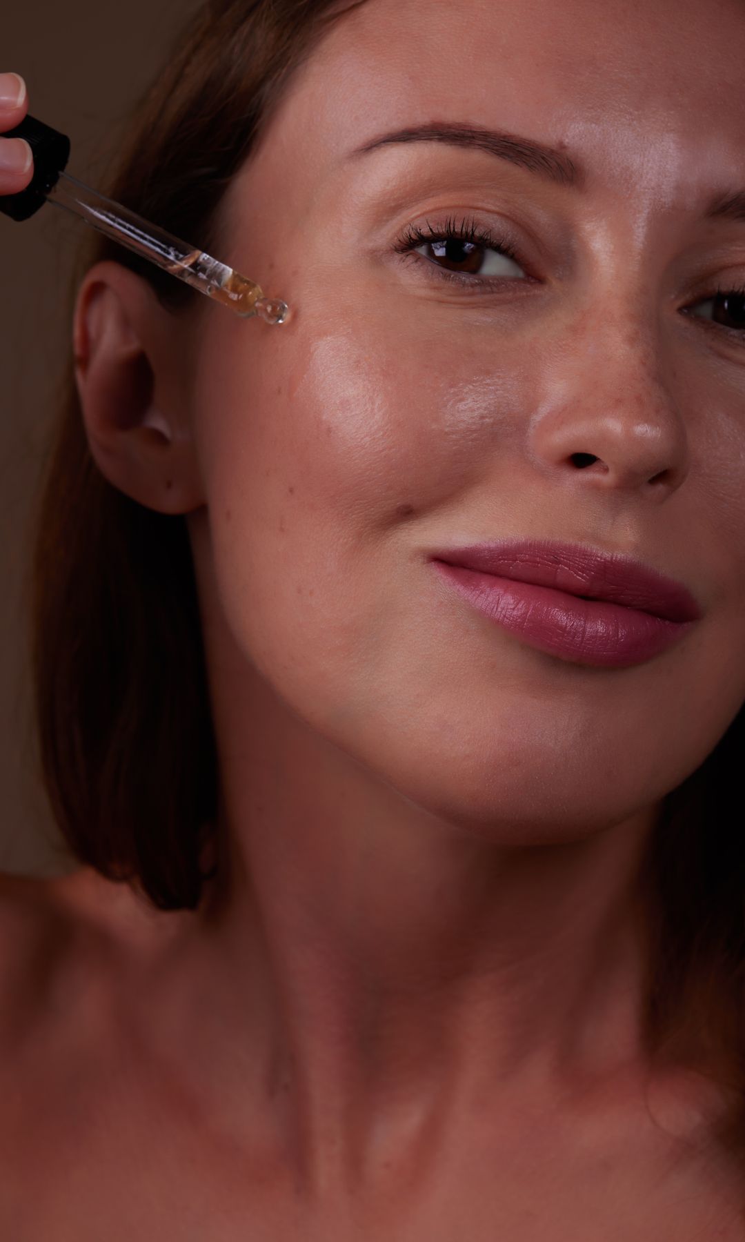 Una chica poniéndose sérum en la cara