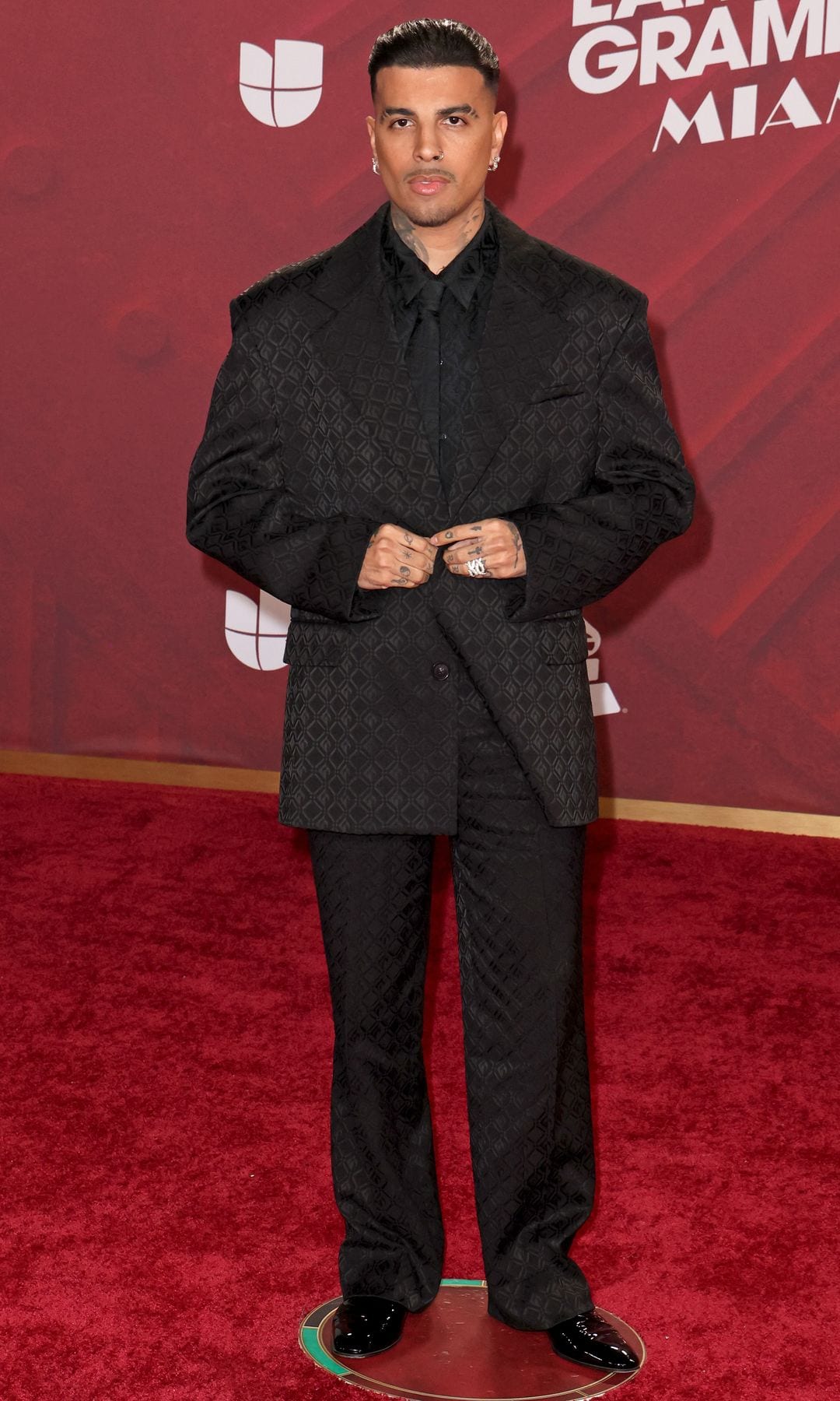 Plano entero de Rauw Alejandro con total look negro