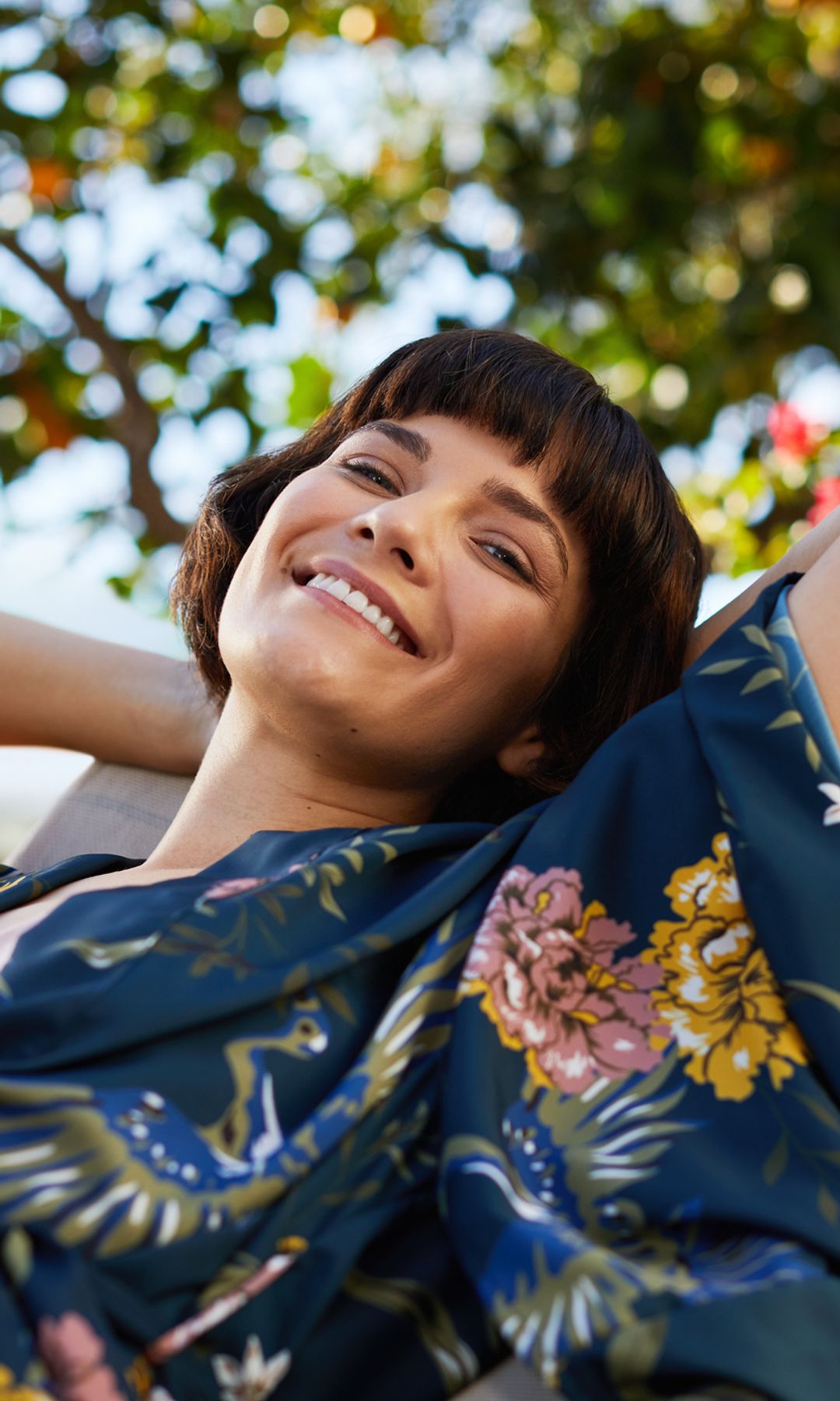 Mujer feliz con los brazos cruzados hacia atrás