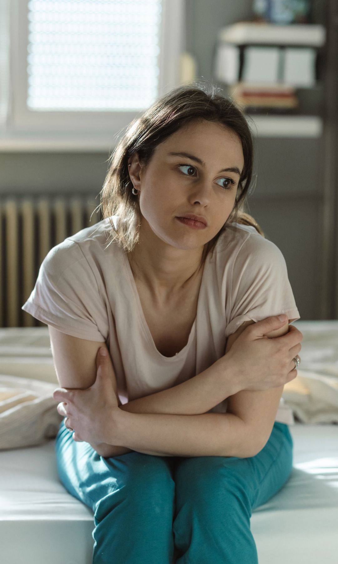 Mujer seria sentada en la cama