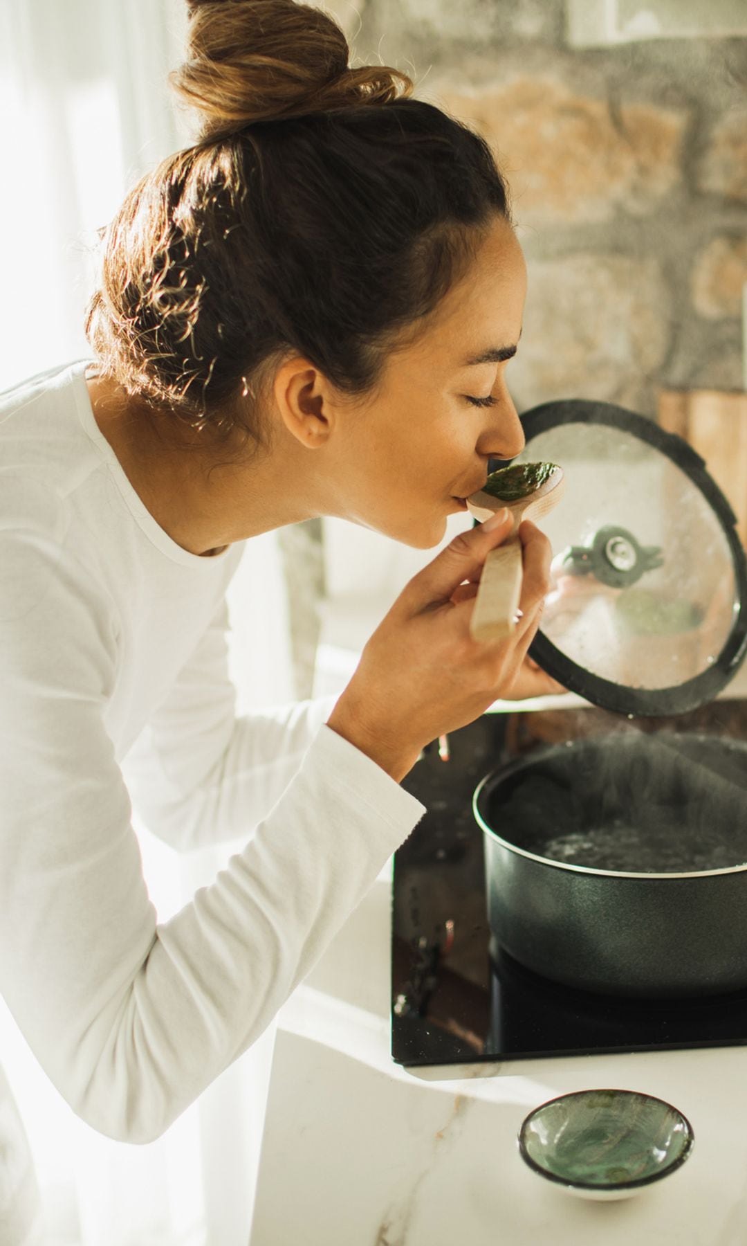 Una mujer preparando un caldo de verduras para recuperarse de su resfriado
