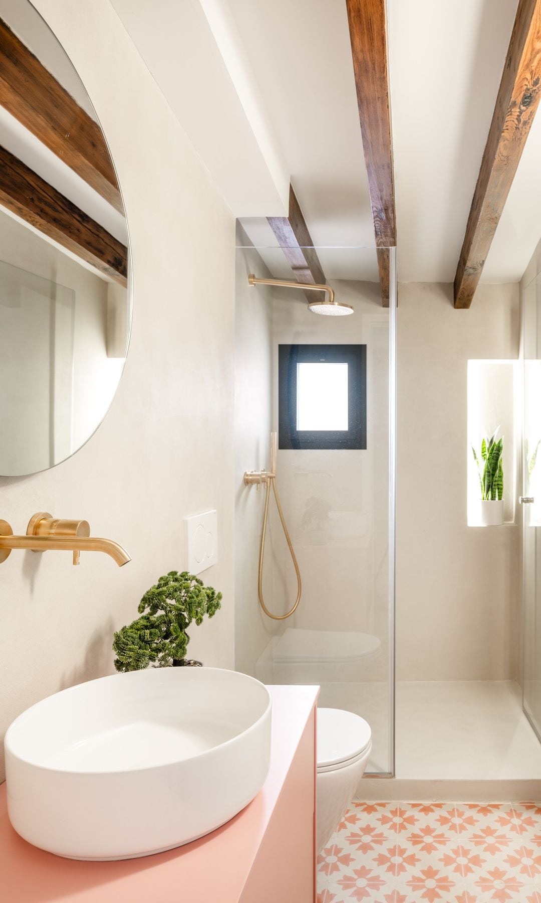 Baño con ducha, suelo hidráulico, vigas de madera, mueble rosa, lavabo redondo blanco, hornacina, radiador toallero