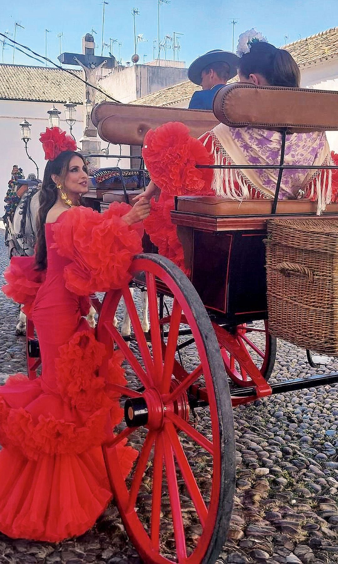 Paloma Cuevas, cogiendo la mano de su hija, sentada en un carruaje