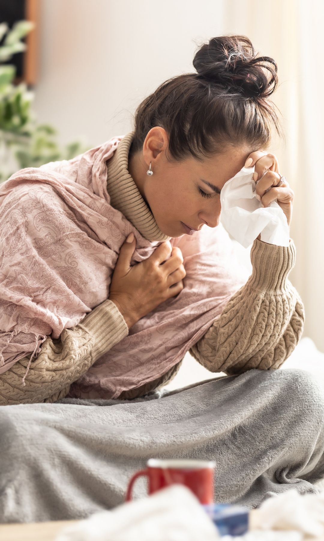 mujer enferma en casa, con un proceso gripal, dolor de cabeza y congestión nasal