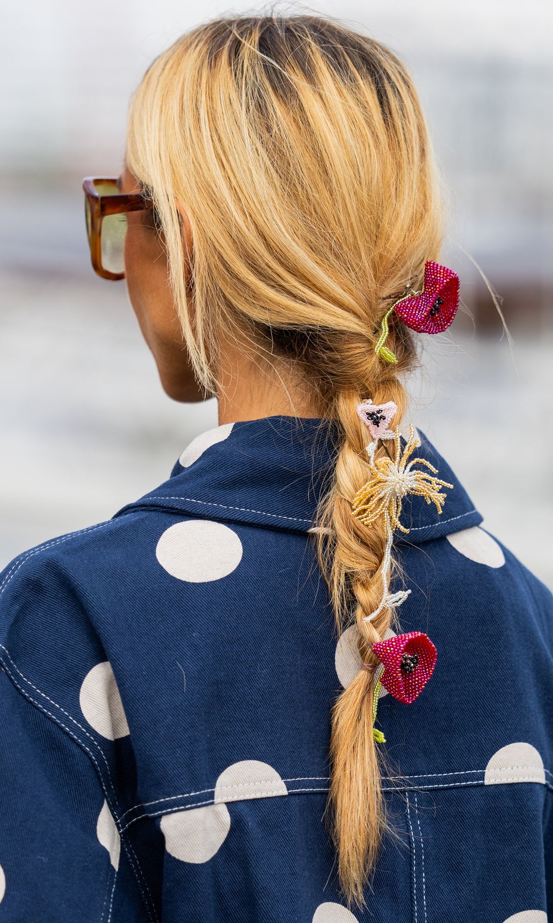 Guiomar Machaz de espaldas con trenza adornada con rosas y cazadora vaquera de lunares blancos