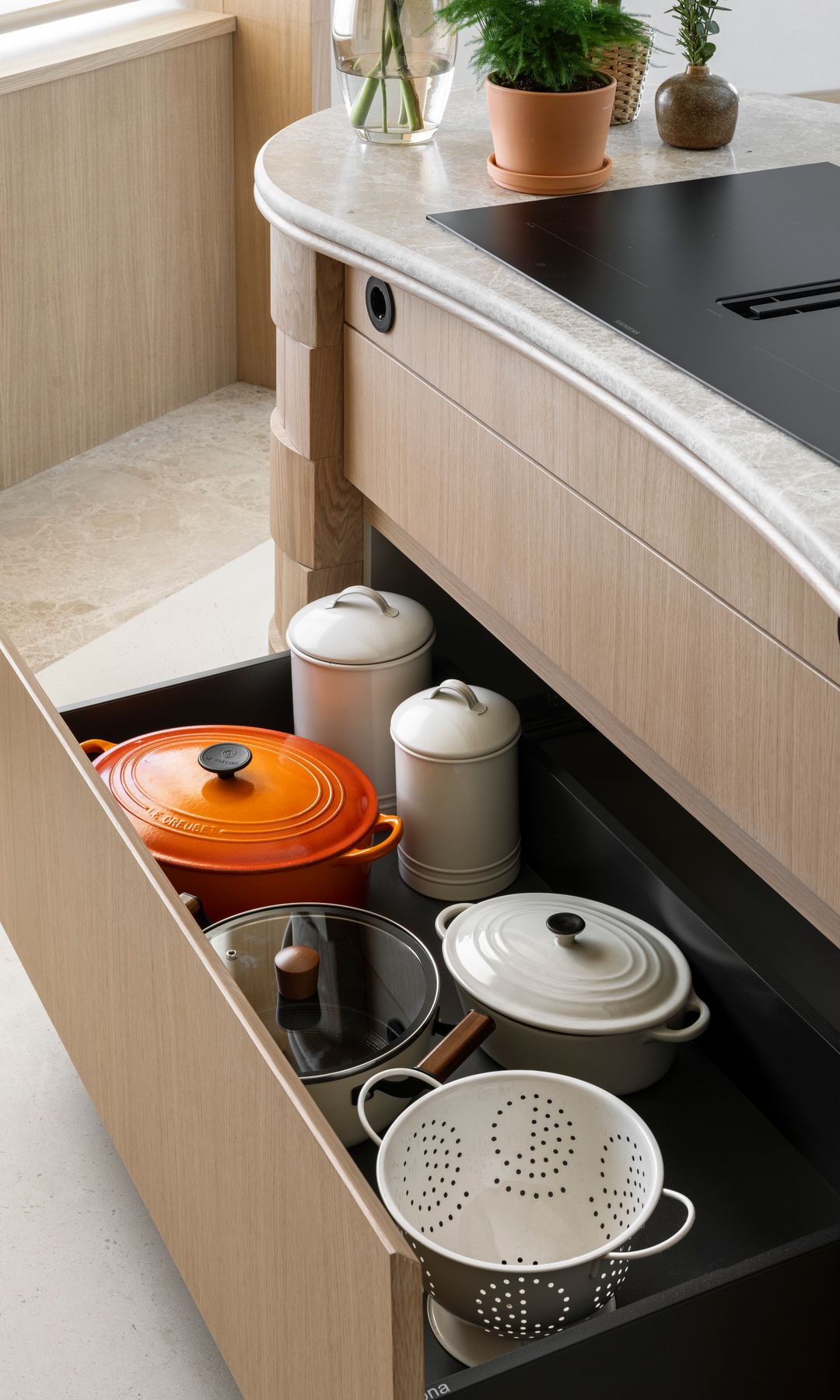 Gaveta de cocina de madera abierto con cazuelas y accesorios