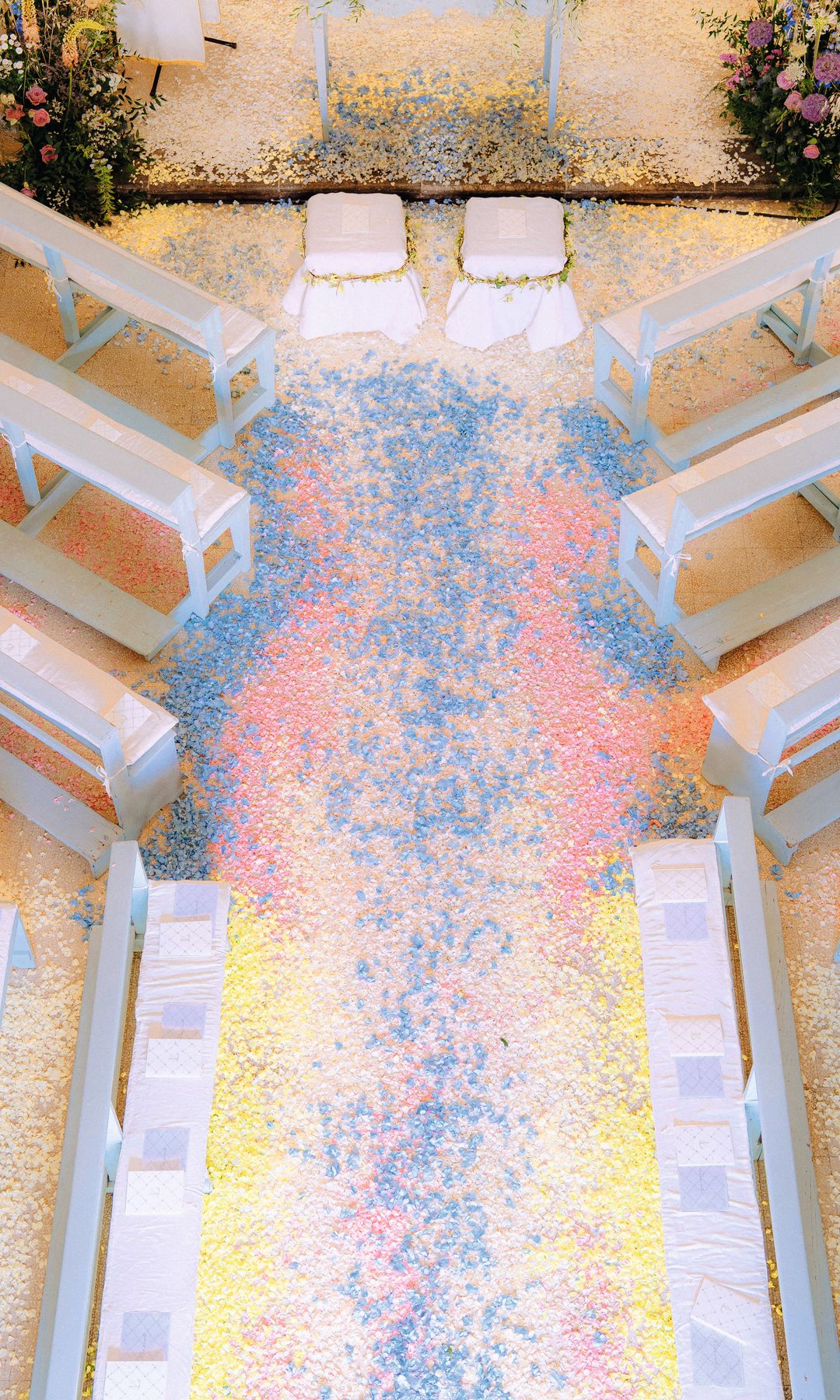 La iglesia vista desde arriba, con el suelo cubierto con pétalos de flores, y un momento de la ceremonia