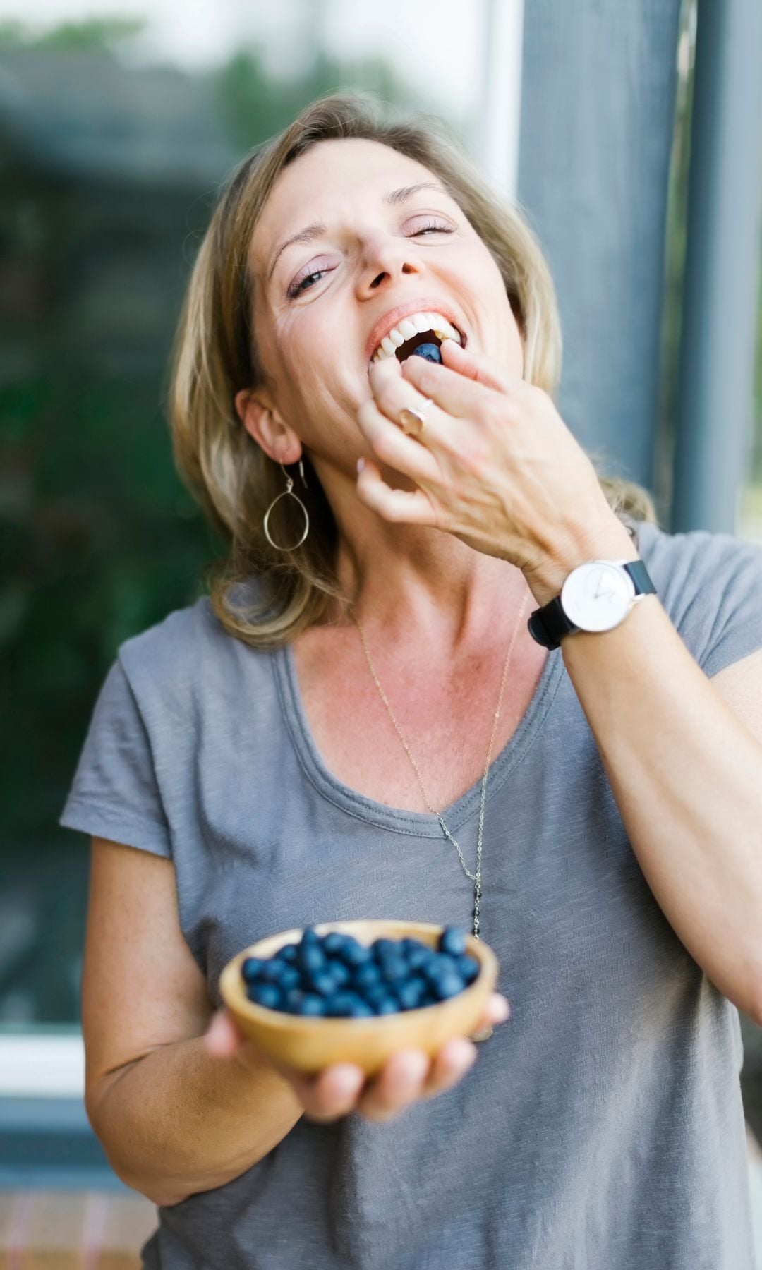 Una mujer comiendo arándanos