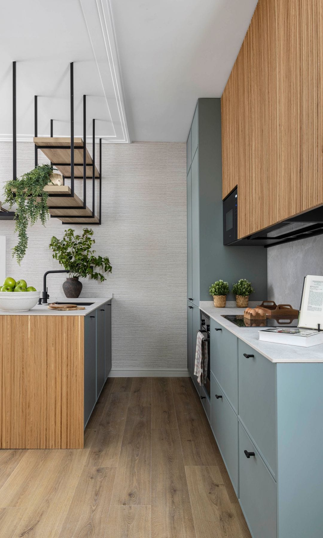 Cocina con isla, muebles hasta el techo de madera, módulos inferiores grises, suelo laminado efecto madera 