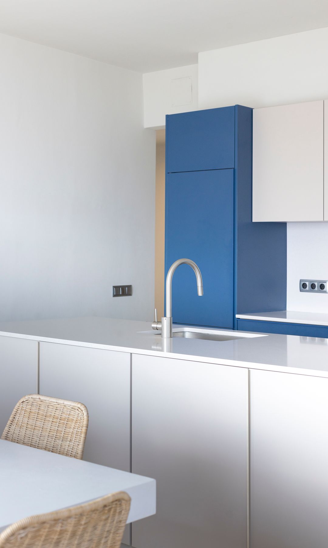 Cocina con isla blanca y muebles azules