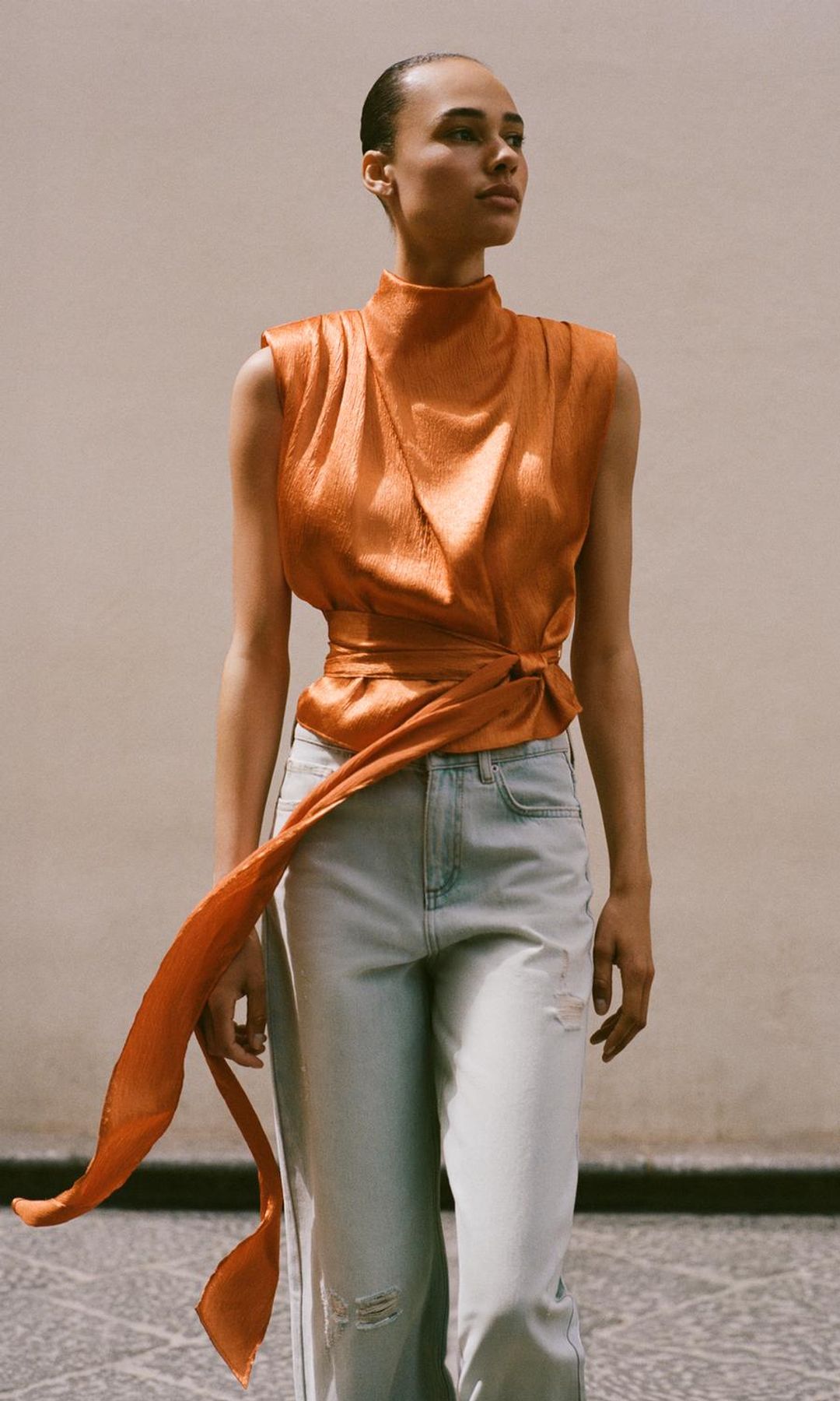Top satinado con lazo en naranja quemado, de Zara