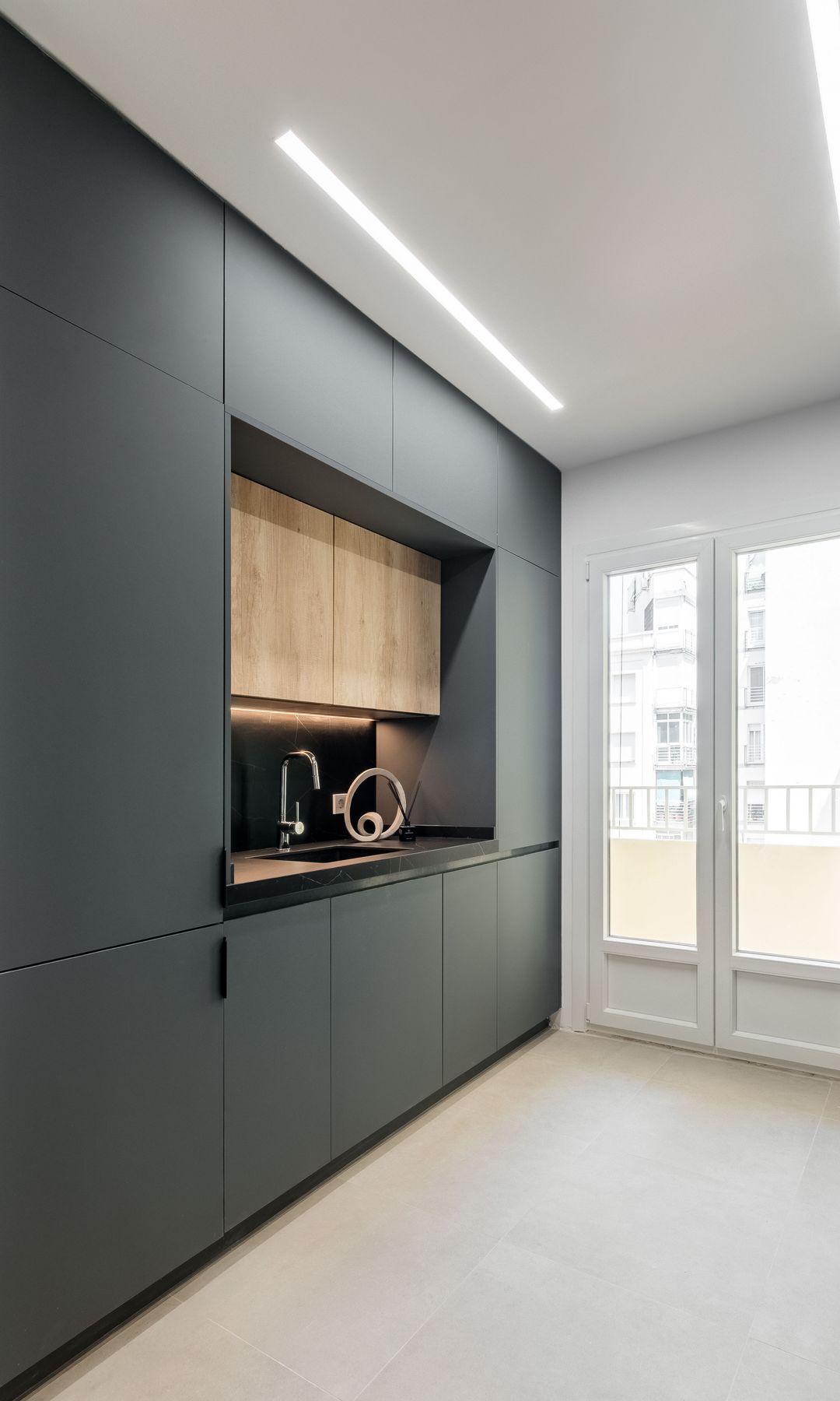 Cocina con muebles negros hasta el techo, salida a la terraza, luz techo
