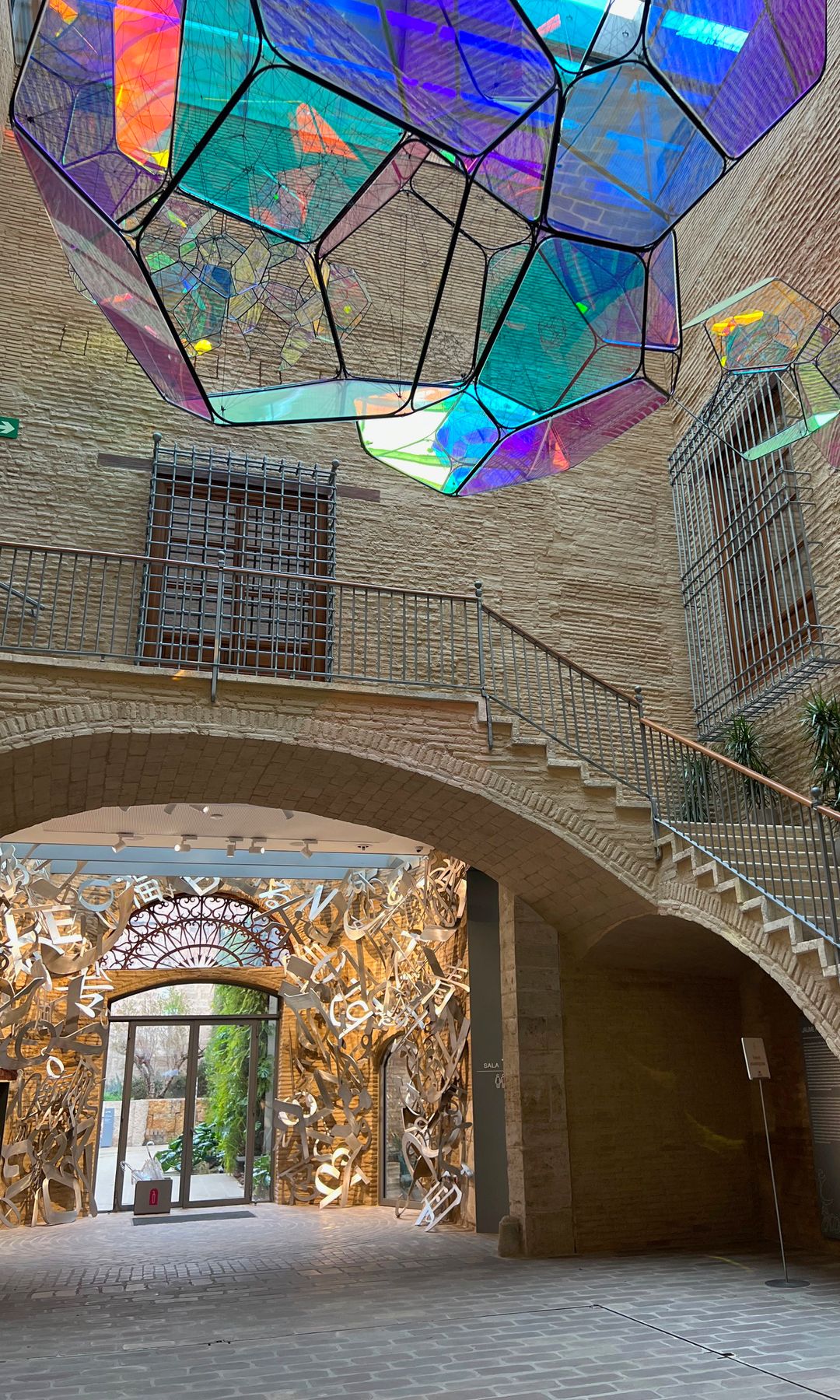 Vestíbulo del centro de arte, con la instalación Corona Australis, del argentino Tomás Saraceno, y salida al patio, con la obra de Jaume Plensa, Centro de Arte Hortensia Herrero, Valencia