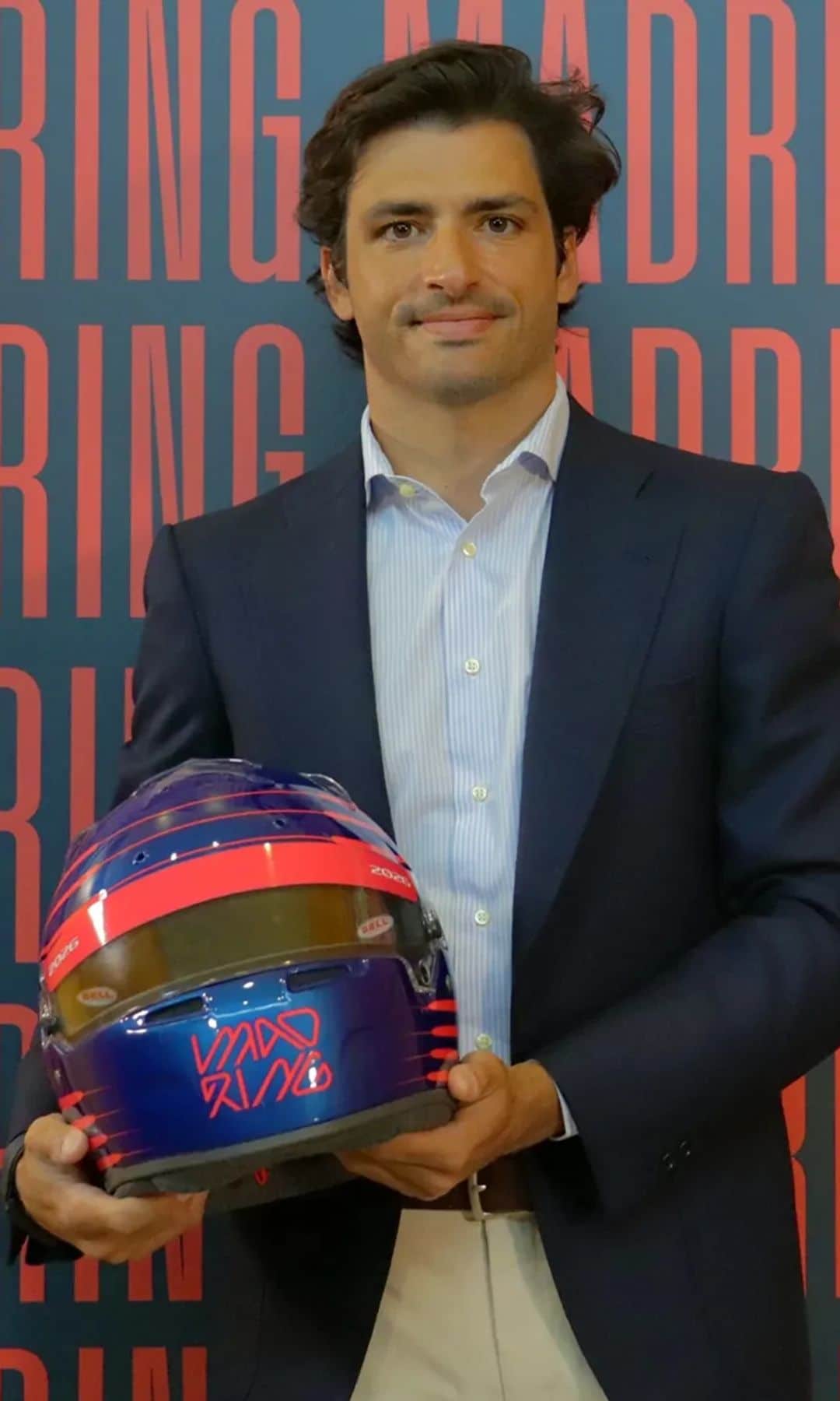 Carlos Sainz posando en el photocall del circuito Madring con un casco en mano