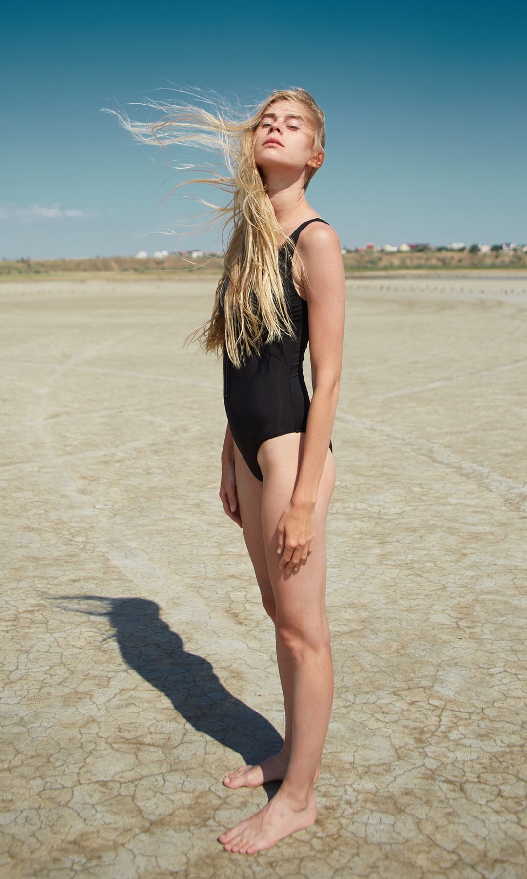 Mujer joven en la playa pensando 
