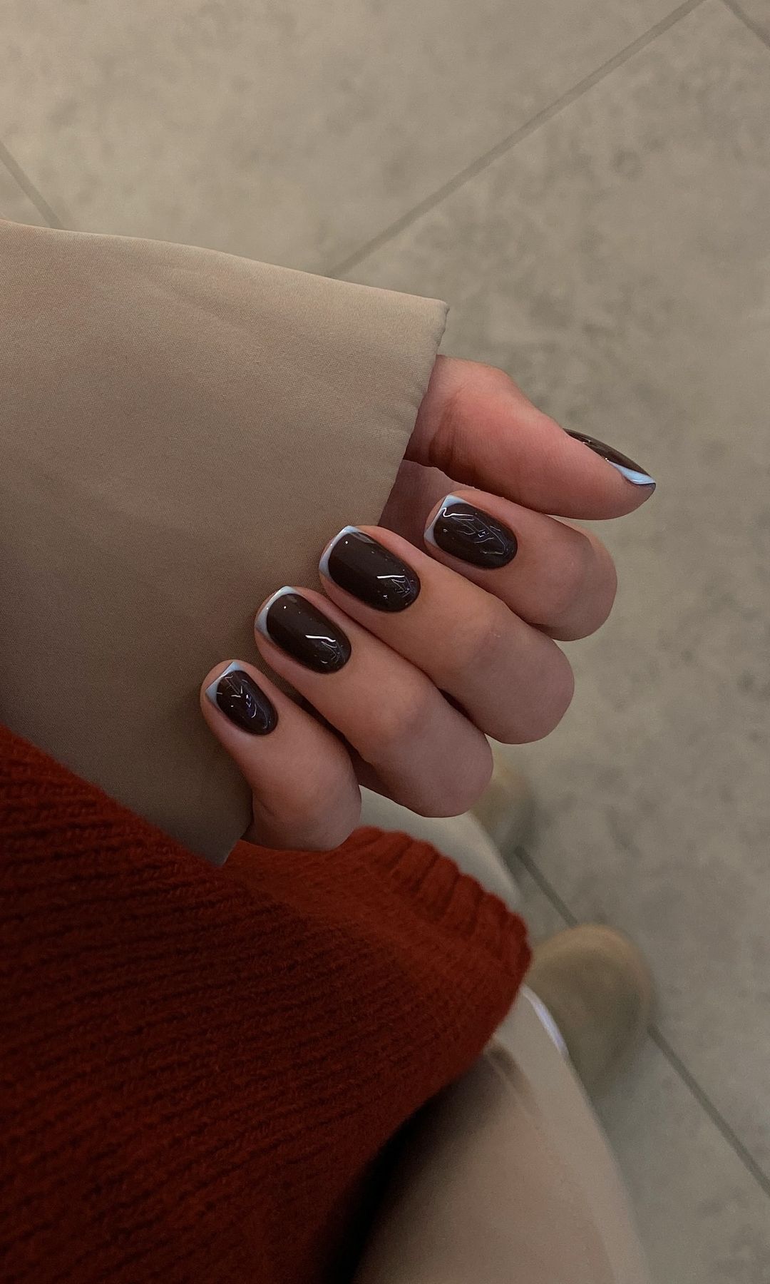 Manicura francesa con base en marrón y línea en azul