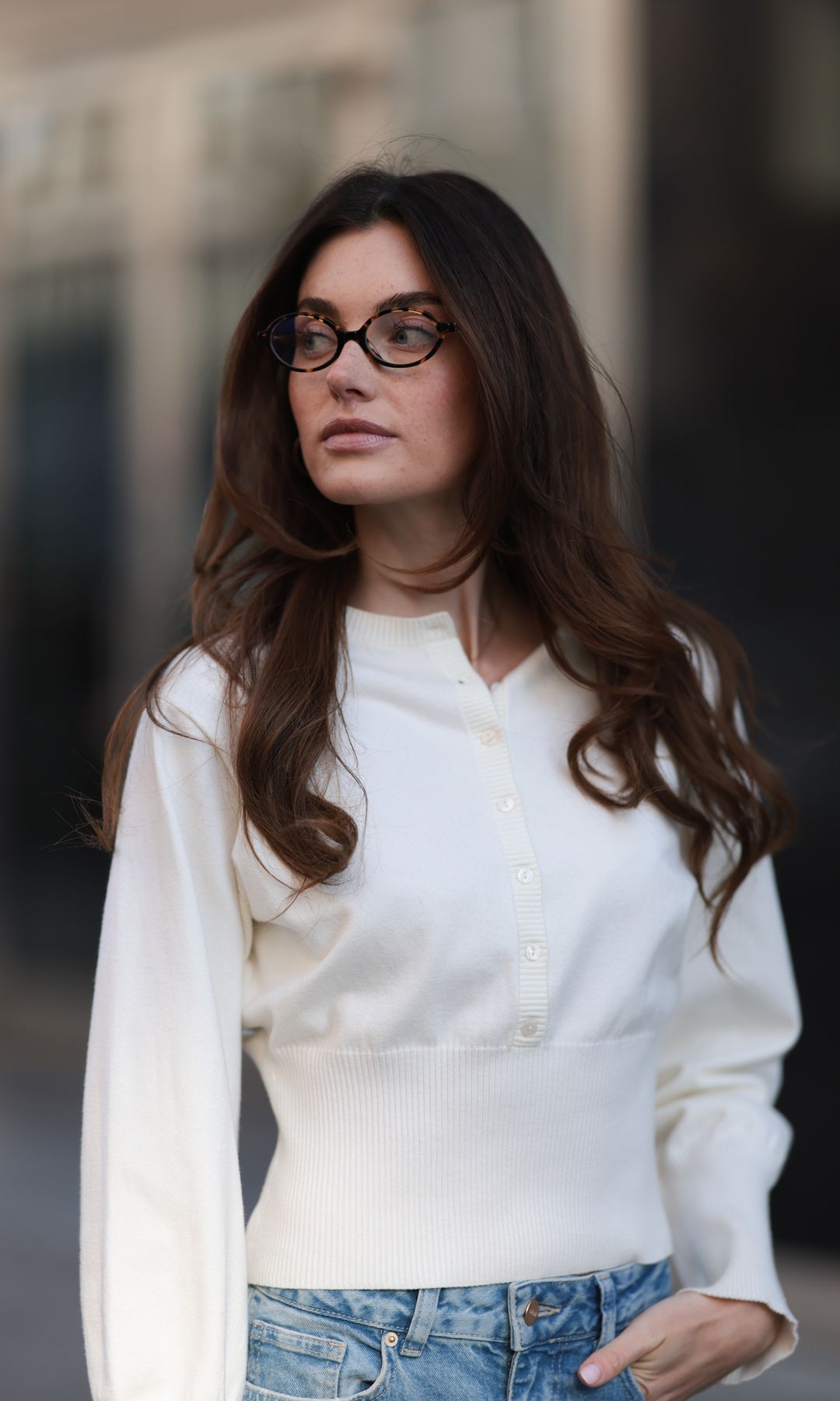 BERLIN, GERMANY - MARCH 21: Celine Bethmann seen wearing Miu Miu brown oval framed statement glasses, Cie Cie fitted ivory long-sleeve cotton henley top with a structured waist detail, Cie Cie high-waisted, light-wash wide-leg jeans that add a relaxed yet sophisticated touch, on March 21, 2025 in Berlin, Germany.