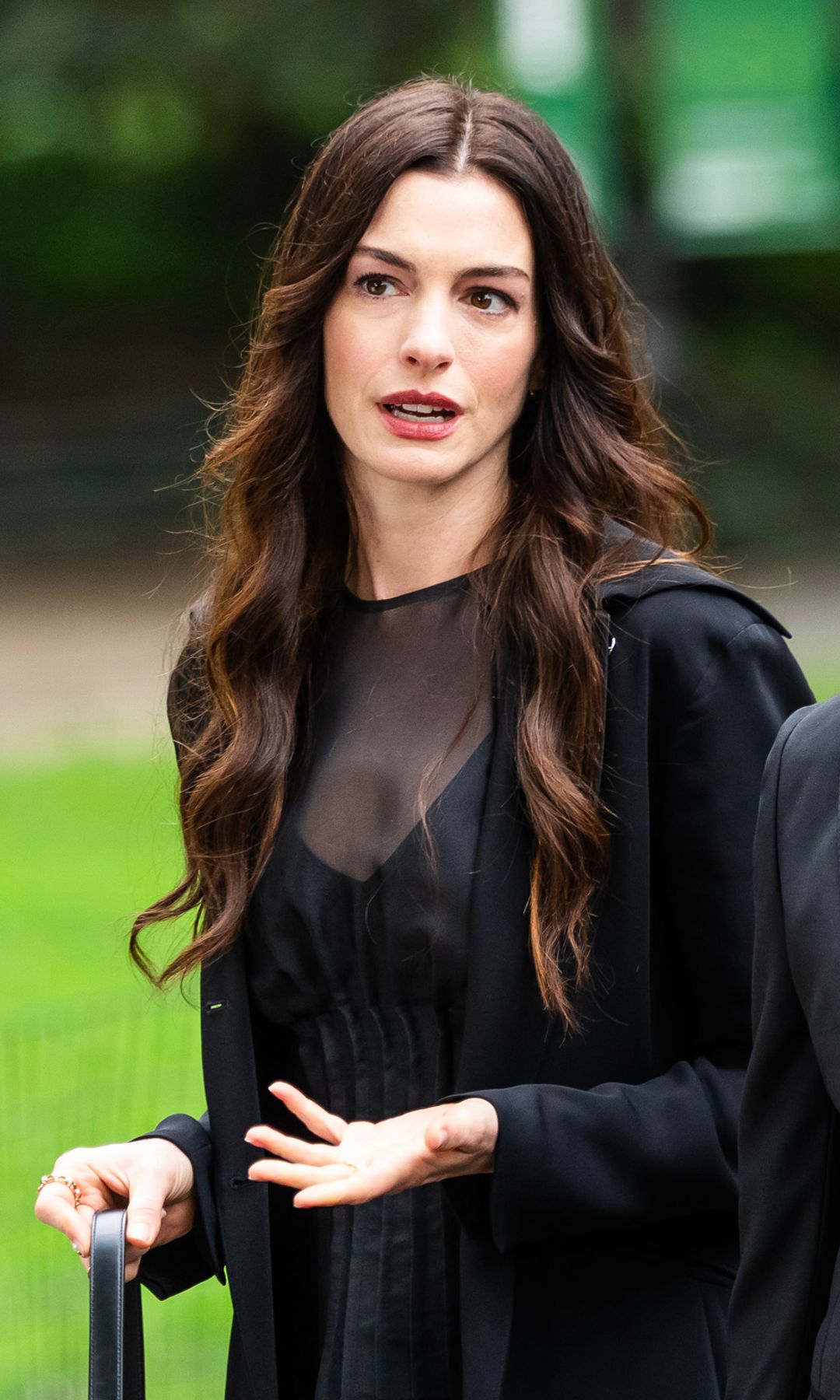 Anne Hathaway con vestido negro y abrigo en el rodaje de El Diablo viste de Prada 2