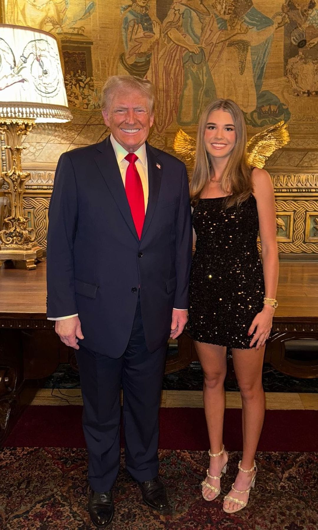 Plano entero de Donald Trump posando con su nieta Kai