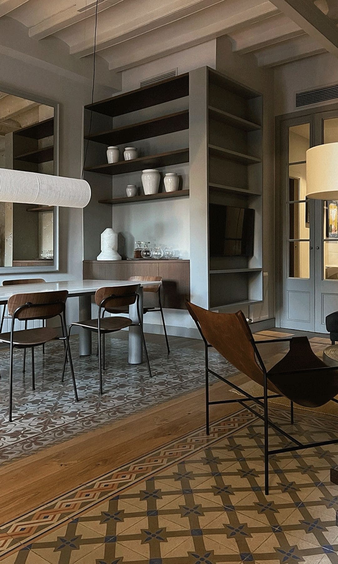 Salón comedor con suelo hidráulico, diferente en ambas zonas, vigas de madera blancas, lámpara de techo, rincón de lectura