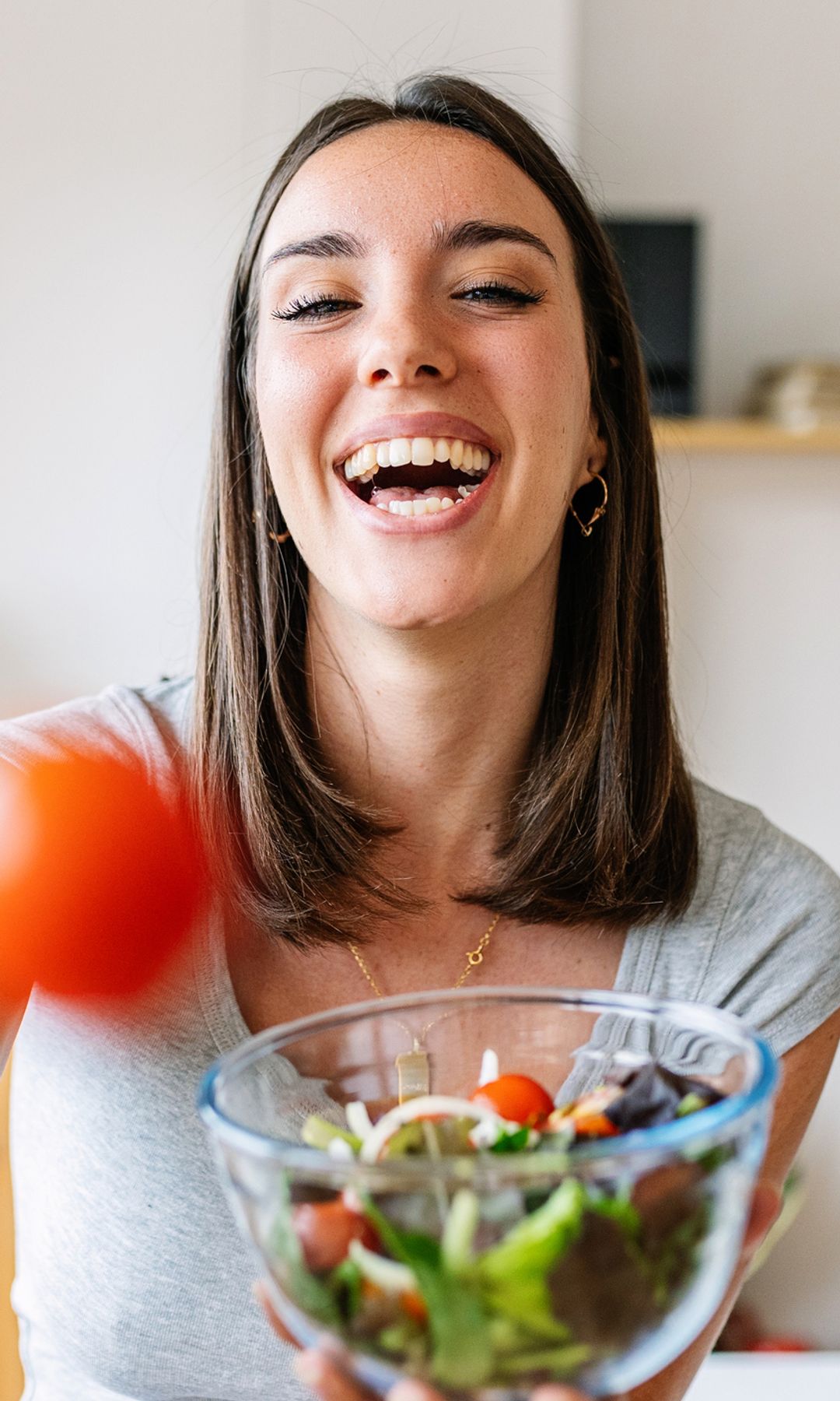 Mujer muy feliz con una ensalada para cuidar su microbiota según las indicaciones del Dr. Mario Alonso Puig 