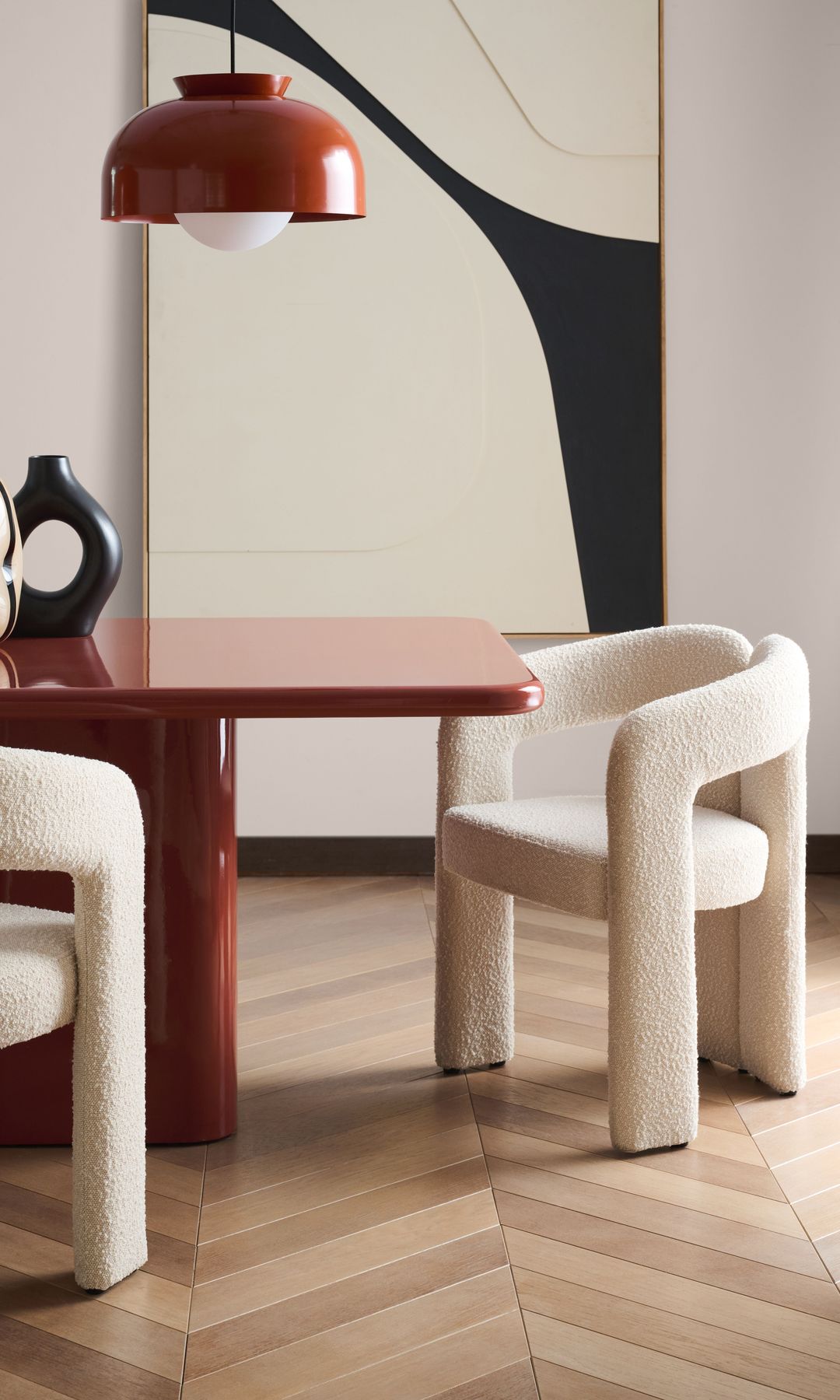 Comedor con mesa roja, lámparas de techo rojas, sillas blancas redondas de lana bouclé